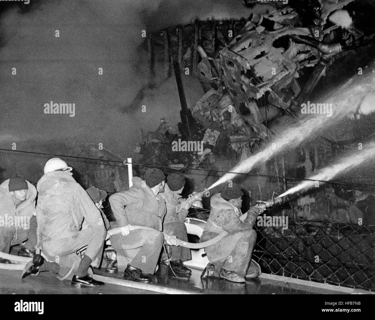 Vigili del fuoco a bordo del missile destroyer USS CLAUDE V. RICKETTS (DDG 5) spruzzo diretto da loro i tubi flessibili su un incendio a bordo del missile cruiser USS BELKNAP (CG 26). La BELKNAP fu gravemente danneggiata e ha preso fuoco quando esso entra in collisione con la portaerei USS John F. Kennedy (CV 67) durante le operazioni notturne. DN-SN-87-07338 USS Claude V. Ricketts spray per USS Belknap 19751122 Foto Stock