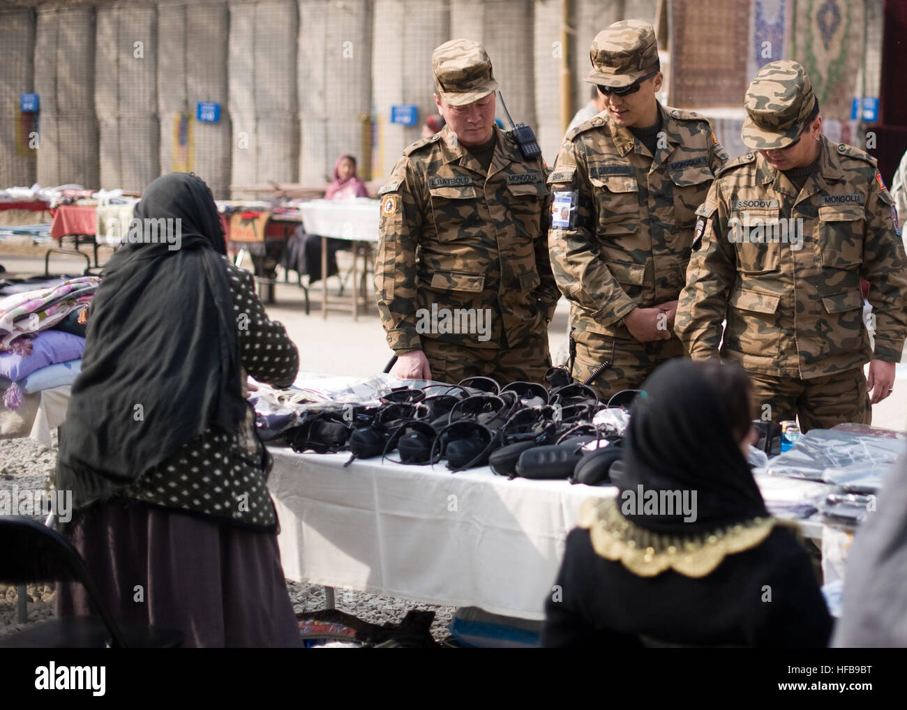 Soldati mongola contrattare prezzi a donne solo fornitori bazaar a Kabul, Afghanistan, Gennaio 28, 2011. La NATO Training Mission-Afghanistan supportato bazaar autorizza le donne a farsi carico della loro sicurezza economica e di essere indipendente in ciò che è altrimenti un maschio dominato la società. Potenziando le donne afghane 361463 Foto Stock