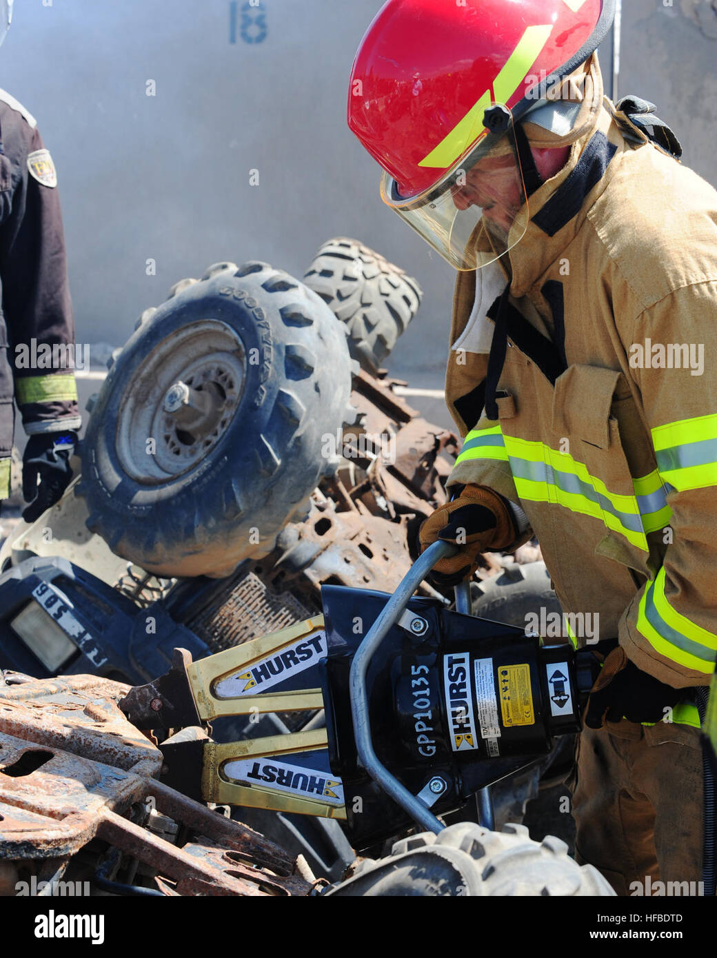 Camp Lemonnier fire department Capt. James Redpath affilatrici per il suo salvataggio competenze di estrazione utilizzando un attrezzo divaricatore durante un esercizio di formazione. La base di vigili del fuoco praticata attrezzature di salvataggio tecniche di intervento su tutti i veicoli fuoristrada che sono pianificate per essere scartato. (U.S. Navy foto/Lt. Brian Badura) vigili del fuoco in treno in Gibuti 216157 Foto Stock