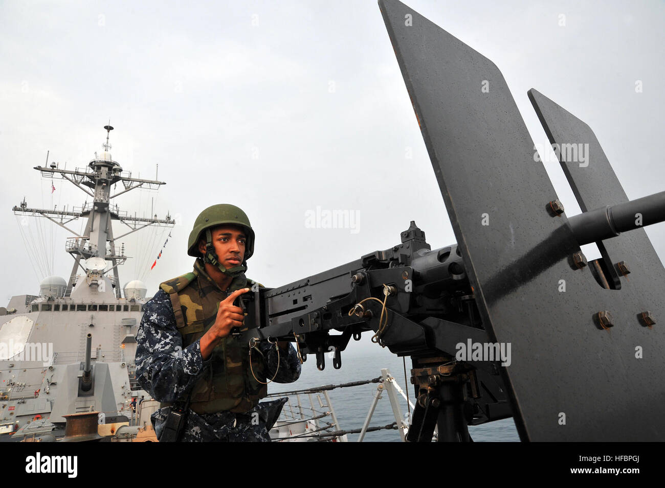 Stretto di Malacca (ott. 6, 2012) della nave marinaio Veteran Alexander Bryant, assegnato all'Arleigh Burke-class guidato-missile destroyer USS McCampbell (DDG 85), mans un .calibro 50 pistola della macchina mentre la nave è in corso nello Stretto di Malacca. McCampbell è parte del George Washington Carrier Strike gruppo e sta conducendo una pattuglia del Pacifico occidentale. America's marinai sono Warfighters, un veloce e flessibile di vigore distribuite in tutto il mondo. Partecipa alla conversazione sui social media utilizzando #combattimento. (U.S. Foto di Marina di Massa Specialista comunicazione marinaio Declan Barnes/RILASCIATO) 121006-N-TG831-061 Foto Stock