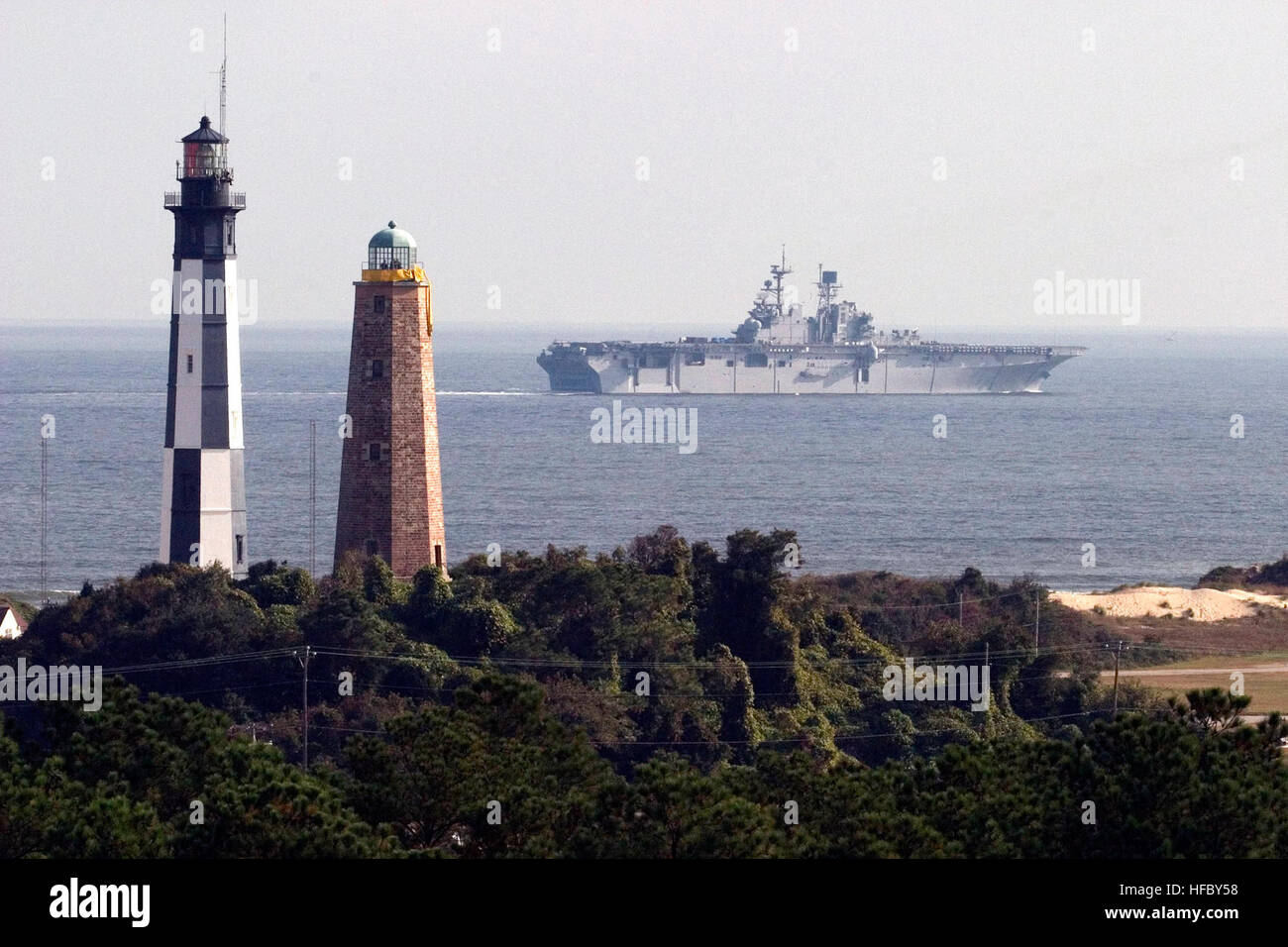 041028-N-0318R-001 Oceano atlantico (ott. 28, 2004) Ð l'assalto anfibio nave USS Bataan (LHD 5) passa il Fort Story faro sul suo modo al oceano Atlantico per prove in mare. Questo è il primo crewÕs periodo in corso dopo il completamento di un esteso di sei-mese disponibilità alla costruzione navale di Norfolk e Drydock Corporation. Stati Uniti Navy foto di PhotographerÕs mate 1. Classe Ken Riley (rilasciato) Fort Story fari Foto Stock