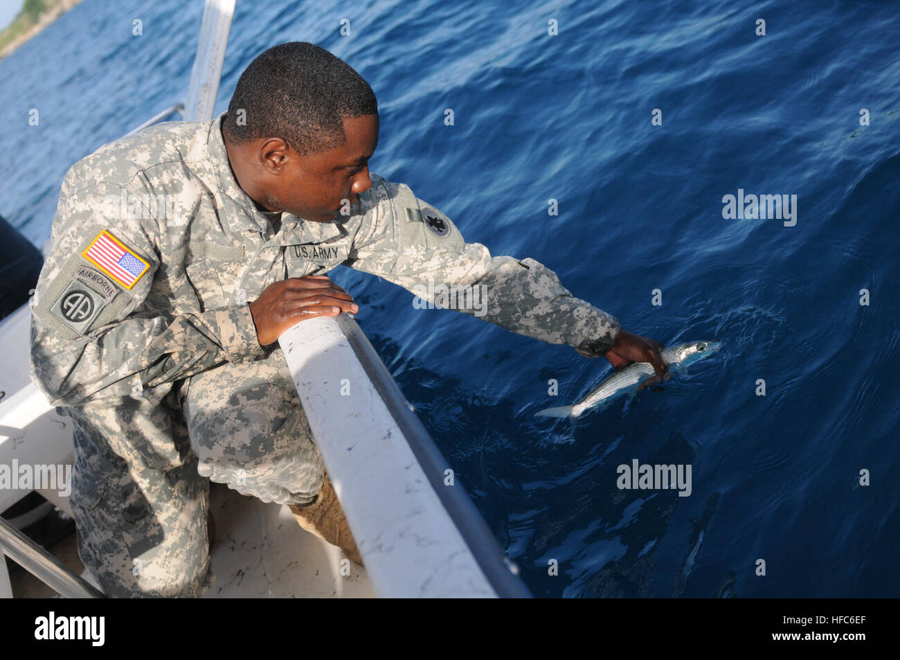Spc. Howard Jones, un armorer per la 189Polizia Militare Company, rilascia un pesce di nuovo in acqua durante un militare congiunta viaggio di pesca nella baia di Guantanamo, 8 luglio. Jones è una delle diverse truppe di stanza a Joint Task Force e la stazione navale di Guantanamo che si offrono volontari per insegnare nel benessere morale e la ricreazione sponsorizzato basic lezioni di pesca. Militare congiunta viaggio di pesca 110708-N-MN220-172 Foto Stock