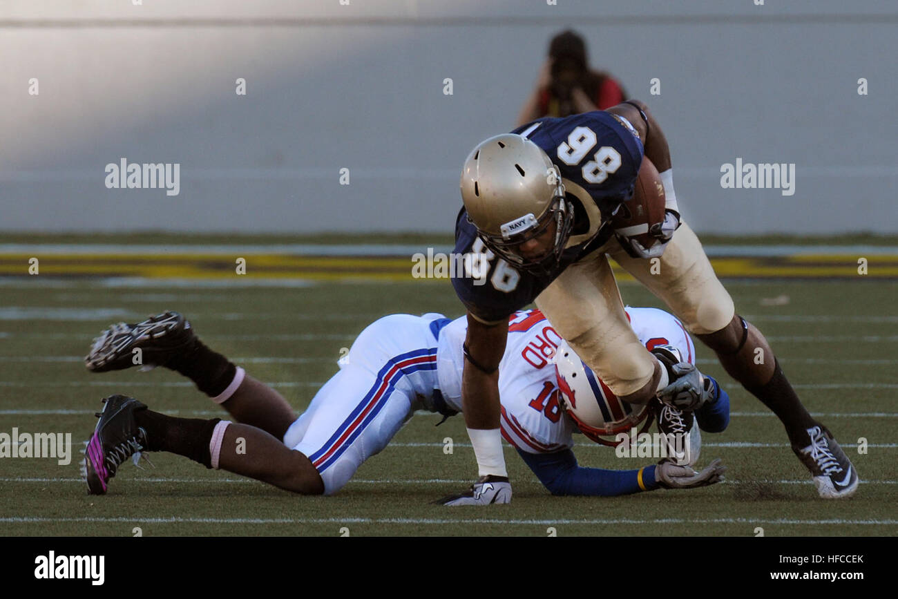 Durante una partita di football universitario alla U.S. Naval Academy, il wide receiver Brandon Turner rompe un tackle da un defensive back della Southern Methodist University. I Midshipmen vinsero la partita 28-21, dimostrando abilità atletica e lavoro di squadra in un ambiente sportivo competitivo ad Annapolis, Maryland, il 16 ottobre 2010. Foto Stock