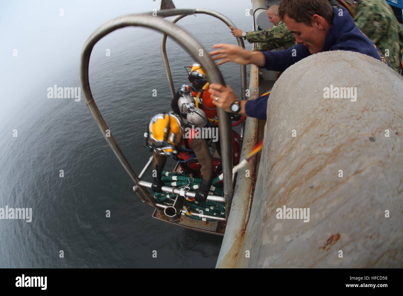 I subacquei, assegnato a Mobile Diving e unità di soccorso (MDSU) 2, e il giunto POW/mia contabilità (Comando JPAC), vengono abbassati in acqua per condurre un recupero di immergersi nel golfo di San Lorenzo. Una 50-persona del team di recupero dal JPAC, MDSU 2, e civili di marinai da la USNS benna mordente (T-ARS 53), stanno conducendo scavi subacquei alla ricerca di cinque americani che sono stati persi quando la loro costruttiva PBY-5un aereo si è schiantato nel novembre 1942. JPAC conduce la ricerca globale, recupero e le operazioni di laboratorio per identificare dispersi-per gli americani da conflitti del passato al fine di supportare il dipartimento della difesa Foto Stock