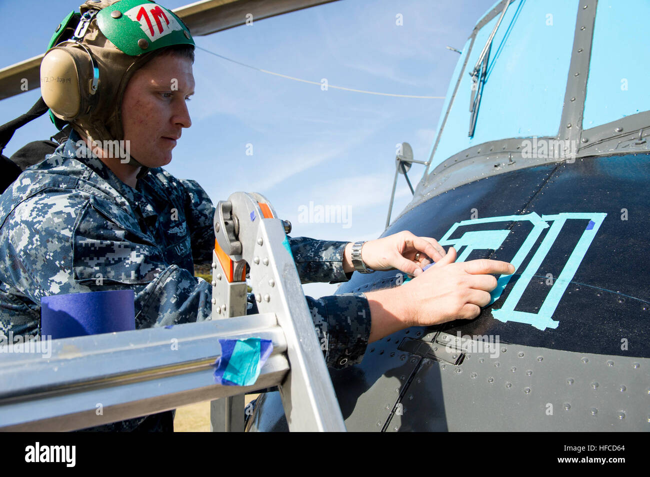 Aviation Structural Mechanic applica nastro stencil a un elicottero modello SH-2F presso la Naval Air Station North Island, parte di un progetto di restauro condotto da Helicopter Maritime Strike Wing Pacific e Helicopter Sea Combat Wing Pacific per esporre modelli di velivoli per mostre navali pubbliche e interne. Foto Stock