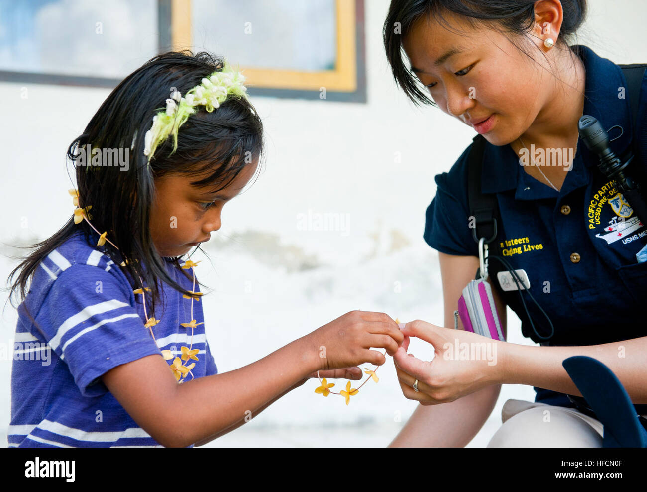 Mindy Li, un volontario con l'Università della California di San Diego società dentale, rende collane di fiori con una ragazza Indonesiane durante una visita medica di azione civile progetto come parte del partenariato Pacifico 2012 in Talaud, Indonesia, 9 giugno 2012. Pacific Partnership è una distribuzione annuale degli sforzi volti a rafforzare la maritime e partenariati umanitario durante il disaster relief operations, mentre la fornitura di aiuto umanitario, medico, dentistico e assistenza tecnica alle nazioni del Pacifico. (U.S. Foto di Marina di Massa lo specialista di comunicazione di terza classe Michael Feddersen) pacifico accordo di partenariato 2012 120609 Foto Stock