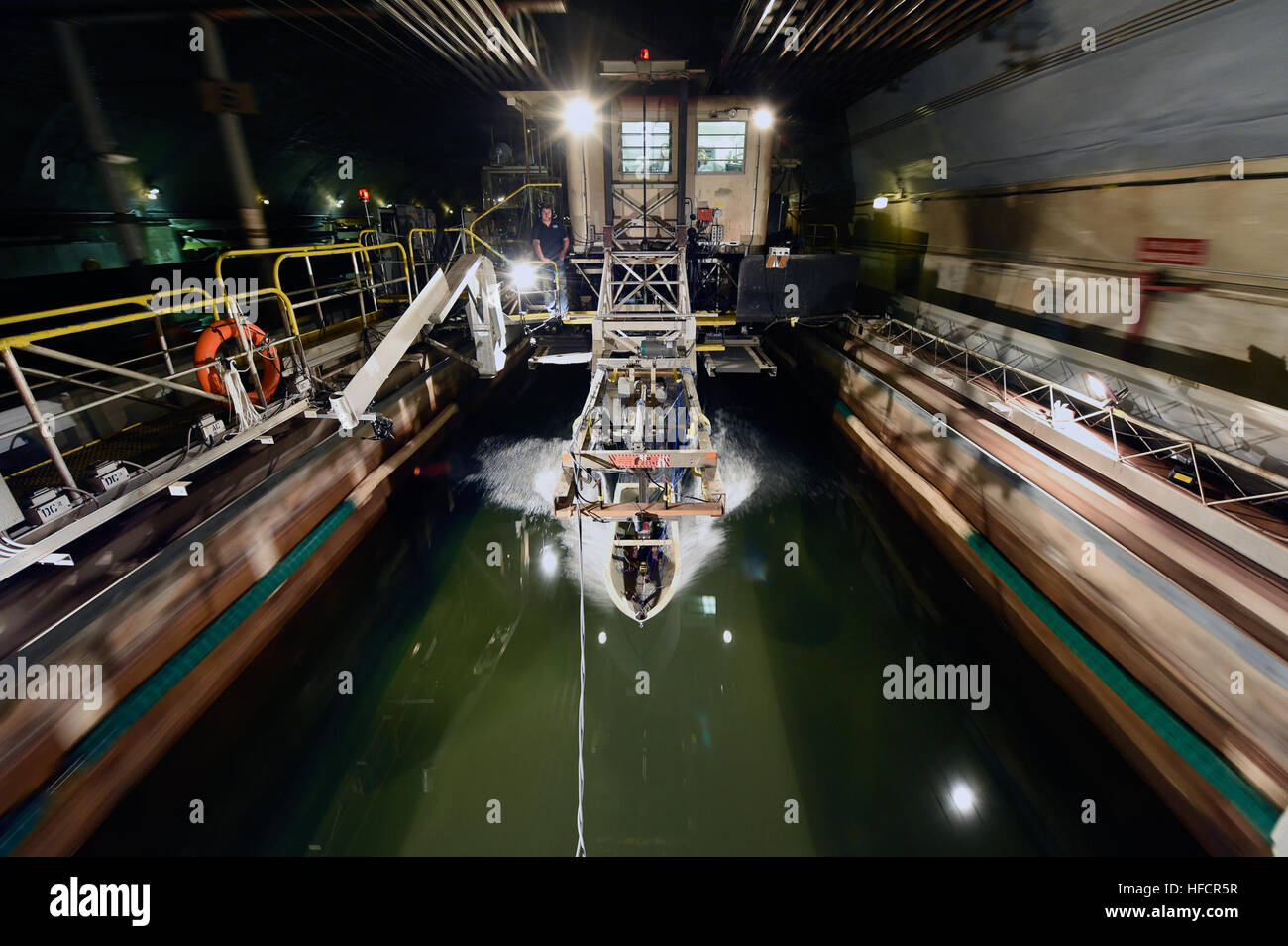 Un modello di scafo collegato a una slitta ad alta velocità viene testato nel bacino modello David Taylor presso il Naval Surface Warfare Center di Carderock per studiare la fisica dell'impatto sull'acqua, i carichi e i movimenti durante il rientro dello scafo planante. La ricerca supporta l'integrità strutturale, la sicurezza dei passeggeri e gli studi di architettura navale. Foto Stock