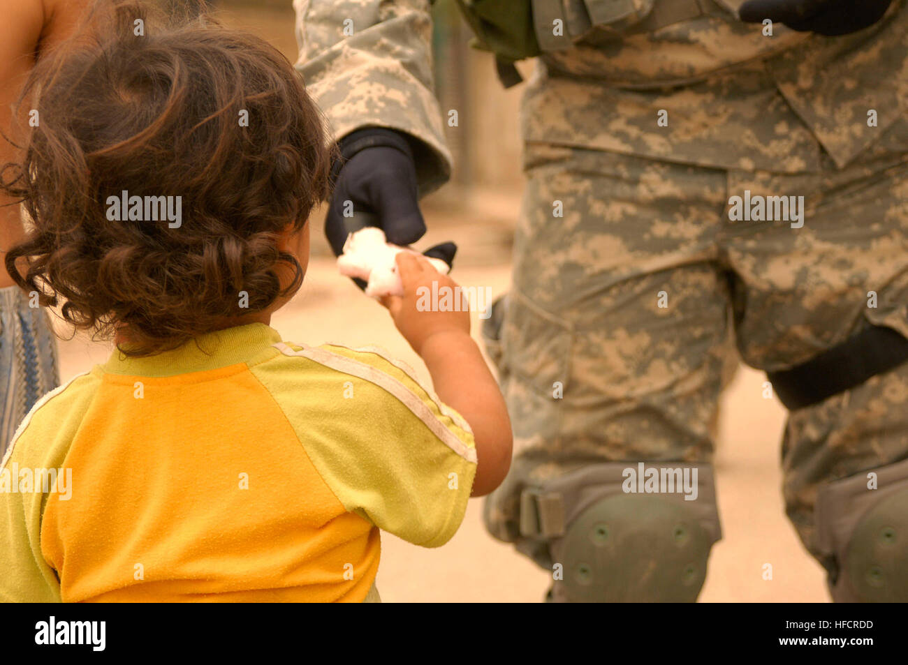 Un iracheno bambino raggiunge fuori per ricevere un puffo da U.S. Soldato. Iracheno di polizia nazionali e degli Stati Uniti Soldati dal 64th Armored reggimento di cavalleria, quarta brigata, terza divisione di fanteria ha cercato una mullalah in Risalah, a Baghdad il 7 settembre 15, 2008, al fine di documentare i militari locali in età maschi residenti lì. Polizia, militari visita i civili iracheni 116297 Foto Stock