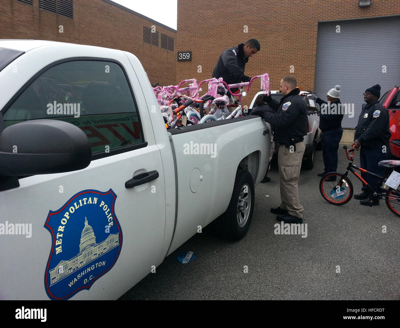 131217-N-CG900-005 WASHINGTON (dec. n. 17, 2012) gli ufficiali di polizia dalla Metropolitan Police Department (MPD) carico biciclette donati per gli Stati Uniti Marine Corps della fondazione di giochi per i più piccoli programma in un carrello di polizia a livello del giunto di base (Anacostia-Bolling JBAB) per il loro trasporto per la distribuzione ai bambini poveri del Distretto di Columbia (D.C.) reparti 7 e 8 (distretti di polizia 6D e 7D). Ogni anno, JBAB-basato Marines coordinare i giochi per i più piccoli programma in D.C.; JBAB basato su elementi militari, civili e contratta i lavoratori e le loro famiglie e i residenti di JBAB volontario per sostenere i giocattoli fo Foto Stock