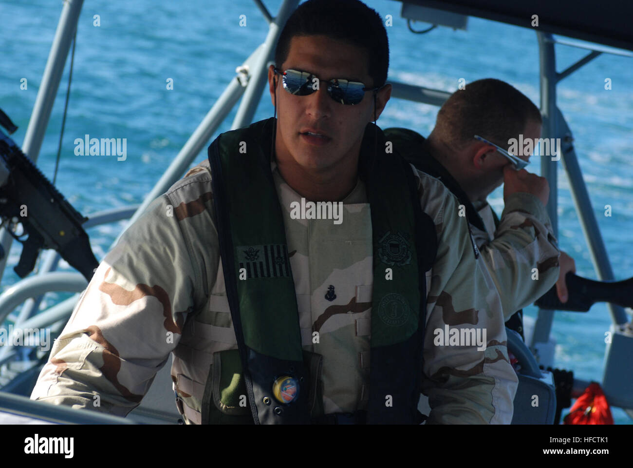 GUANTANAMO Bay a Cuba - Coast Guard Chief Petty Officer Schefano ricco, una tattica timoniere dalla porta unità di sicurezza 307 fuori di Clearwater, Florida, mans timone mentre di pattuglia nella baia di Guantánamo Giugno 10, 2008. PSU 307 fornisce maritime anti-terrorismo e forza di protezione per le acque in ed intorno a U.S. Stazione navale di Guantánamo Bay e Joint Task Force Guantanamo. JTF Guantanamo conduce al sicuro e di assistenza umana e la custodia dei detenuti combattenti ostili. La JTF conduce operazioni di interrogazione per raccogliere intelligence strategica a sostegno della guerra globale al terrorismo e sostiene l'applicazione della legge e w Foto Stock