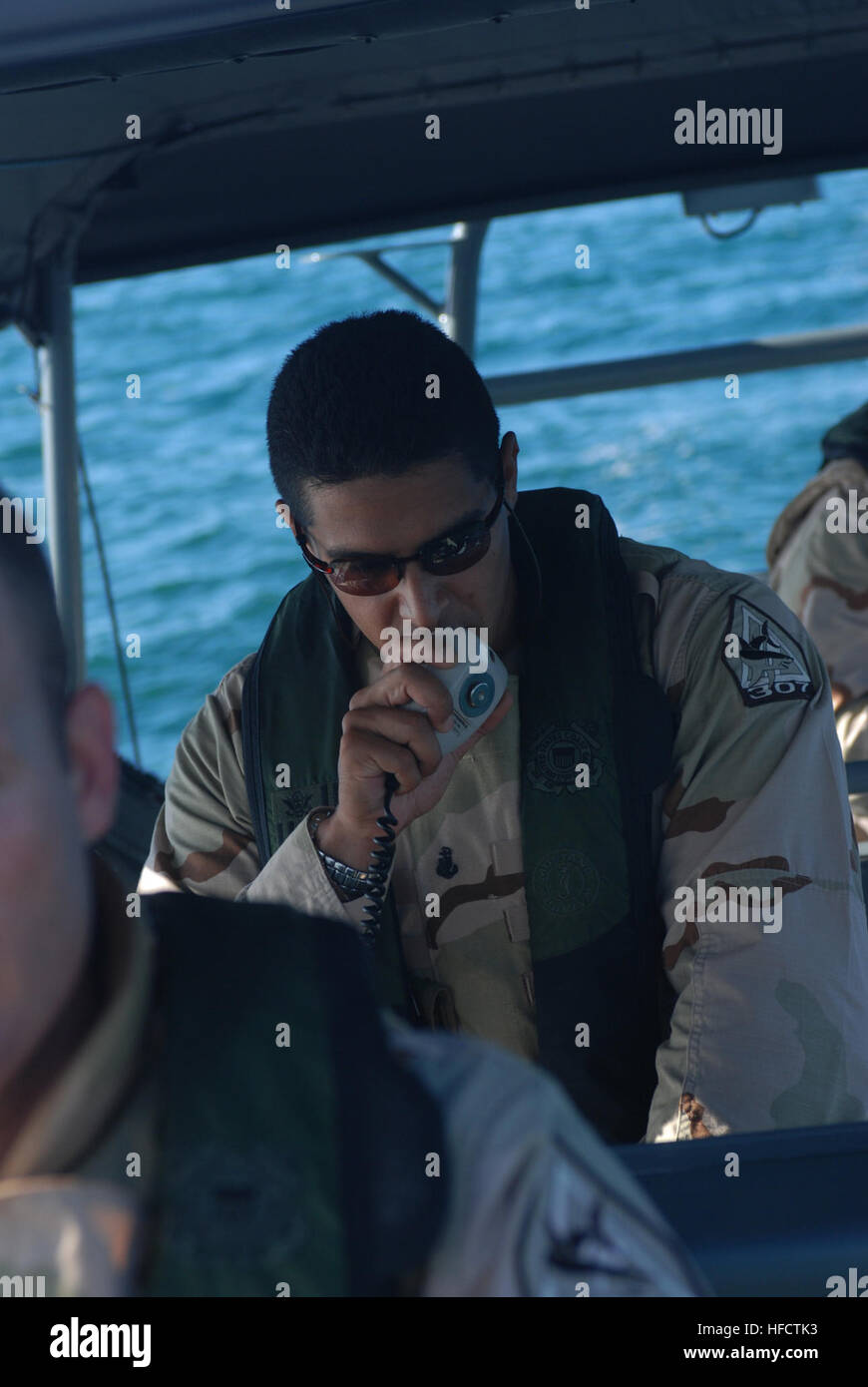 GUANTANAMO Bay a Cuba - Coast Guard Chief Petty Officer Schefano ricco, una tattica timoniere dalla porta unità di sicurezza 307 fuori di Clearwater, Florida, contatti la guardia costiera Stazione di spedizione mentre di pattuglia nella baia di Guantánamo, 10 giugno 2008. PSU 307 fornisce maritime anti-terrorismo e forza di protezione per le acque in ed intorno a U.S. Stazione navale di Guantánamo Bay e Joint Task Force Guantanamo. JTF Guantanamo conduce al sicuro e di assistenza umana e la custodia dei detenuti combattenti ostili. La JTF conduce operazioni di interrogazione per raccogliere intelligence strategica a sostegno della guerra globale al terrorismo e s Foto Stock