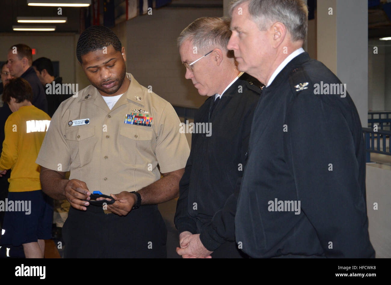 Stati Uniti Nave della marina americana di veterani di prima classe Vernon Salomone, in primo piano a sinistra, visualizza un chip di distribuzione utilizzato da reclute durante l idoneità fisica prove, Adm posteriore. Donald Quinn, centro, comandante della Naval istruzione formazione di comando e il cap. Dee Mewbourne, selezionato per la promozione ad Ammiraglio e Comandante del servizio navale del comando di formazione, in un tour della libertà fisica sala training facility ad assumere il comando di formazione alla stazione navale Grandi Laghi, Ill., Gennaio 24, 2013. (U.S. Navy Foto di Brian Walsh/RILASCIATO) reclutamento di formazione 130124-N-BN978-031 Foto Stock