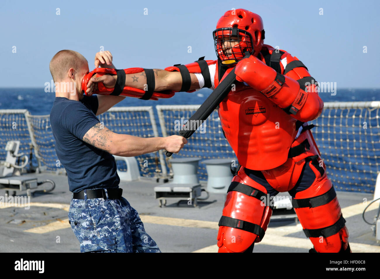 Stati Uniti 5TH FLOTTA AREA DI RESPONSABILITÀ (GEN. 12, 2013) Tecnico Sonar 2a classe Kristopher Sharpe, sinistra, pratiche tattiche non letali sui sistemi di informazione tecnico di terza classe Jasmaine Brooks dopo che viene spruzzato con Oleoresin Capsicum durante la sicurezza della forza di reazione della formazione a bordo guidato-missile destroyer USS Jason Dunham (DDG 109). Jason Dunham è distribuito con il John C. Stennis Carrier Strike gruppo per gli Stati Uniti Quinta Flotta area di responsabilità condurre le operazioni di sicurezza marittima, teatro la cooperazione in materia di sicurezza gli sforzi e le missioni di sostegno per l'Operazione Enduring Freedom. (U.S. Navy Foto Stock