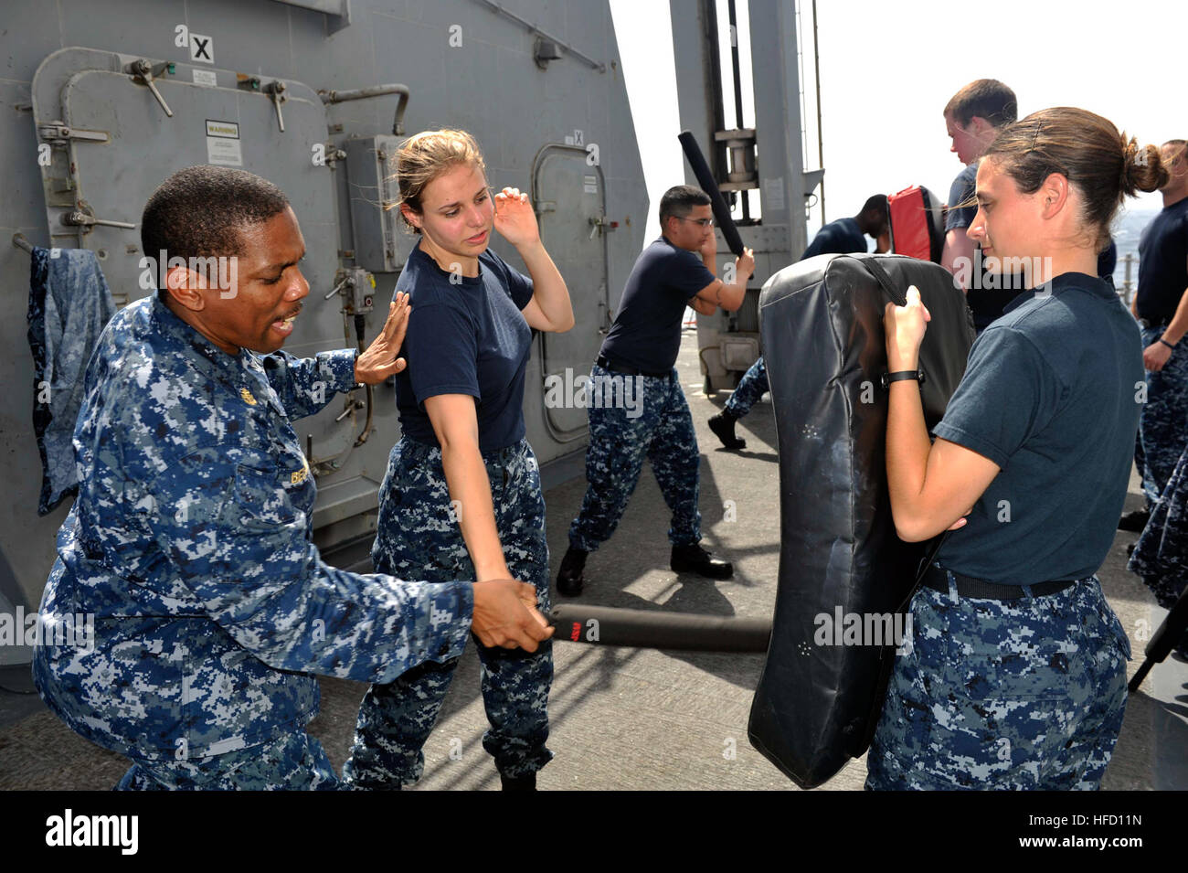 Stati Uniti 5TH FLOTTA AREA DI RESPONSABILITÀ (feb. 5, 2013) Direttore Master-at-Arms Dwayne Belcher incarica Cryptologic tecnico (Raccolta) terza classe Laurie Volz nel modo di utilizzare la corretta non letale tattica su comunicazioni interne elettricista di terza classe Lynzi Miller durante la sicurezza della forza di reazione di formazione di base a bordo guidato-missile destroyer USS Jason Dunham (DDG 109). Jason Dunham è distribuito con il John C. Stennis Carrier Strike gruppo per gli Stati Uniti Quinta Flotta area di responsabilità condurre le operazioni di sicurezza marittima, teatro la cooperazione in materia di sicurezza gli sforzi e le missioni di sostegno per il funzionamento fine Foto Stock