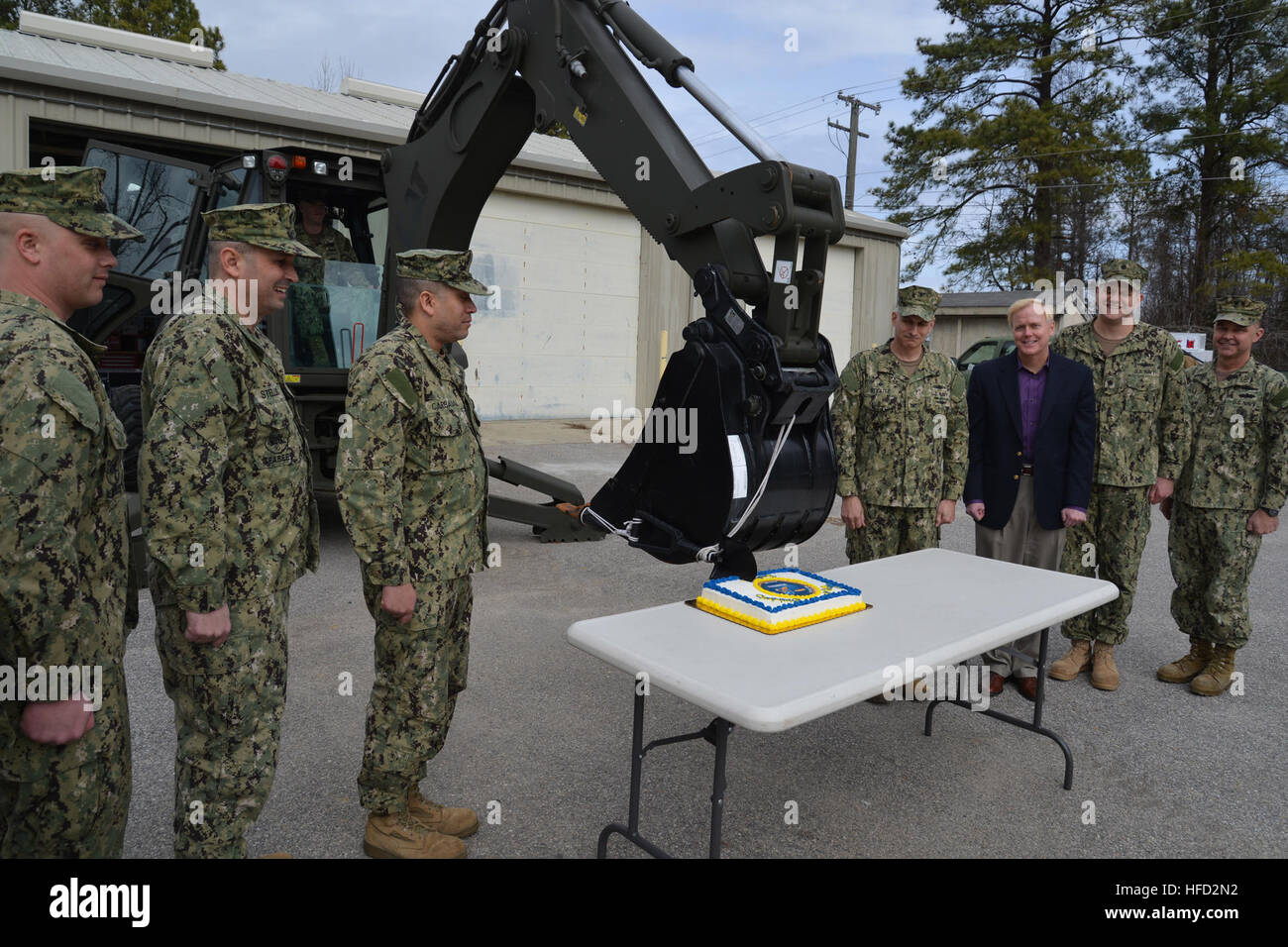 WILLIAMSBURG, Virginia (5 marzo 2013) Operatore dell' attrezzatura di seconda classe Sutheimer Sam, dal Navy Expeditionary supporto logistico (Gruppo NAVELSG), utilizza un consolidamento attrezzo attaccato ad un cucchiaio rovescio per tagliare una torta di compleanno in onore del Seabees' 71st compleanno come shipmates e il personale guarda. Da sinistra, costruzione meccanico 2a classe Evan Zumdick, capo meccanico di costruzione A. Carl Stelling, Lt. La Cmdr. Todd Carbajal, Cap. Michael Stiglitz, vice comandante di NAVELSG; Mark J. Sakowski, capo del personale per NAVELSG; Cmdr. Nathan Johnston; NAVESLG e il comando Master Chief James dolce. (U.S. Navy foto di C Foto Stock