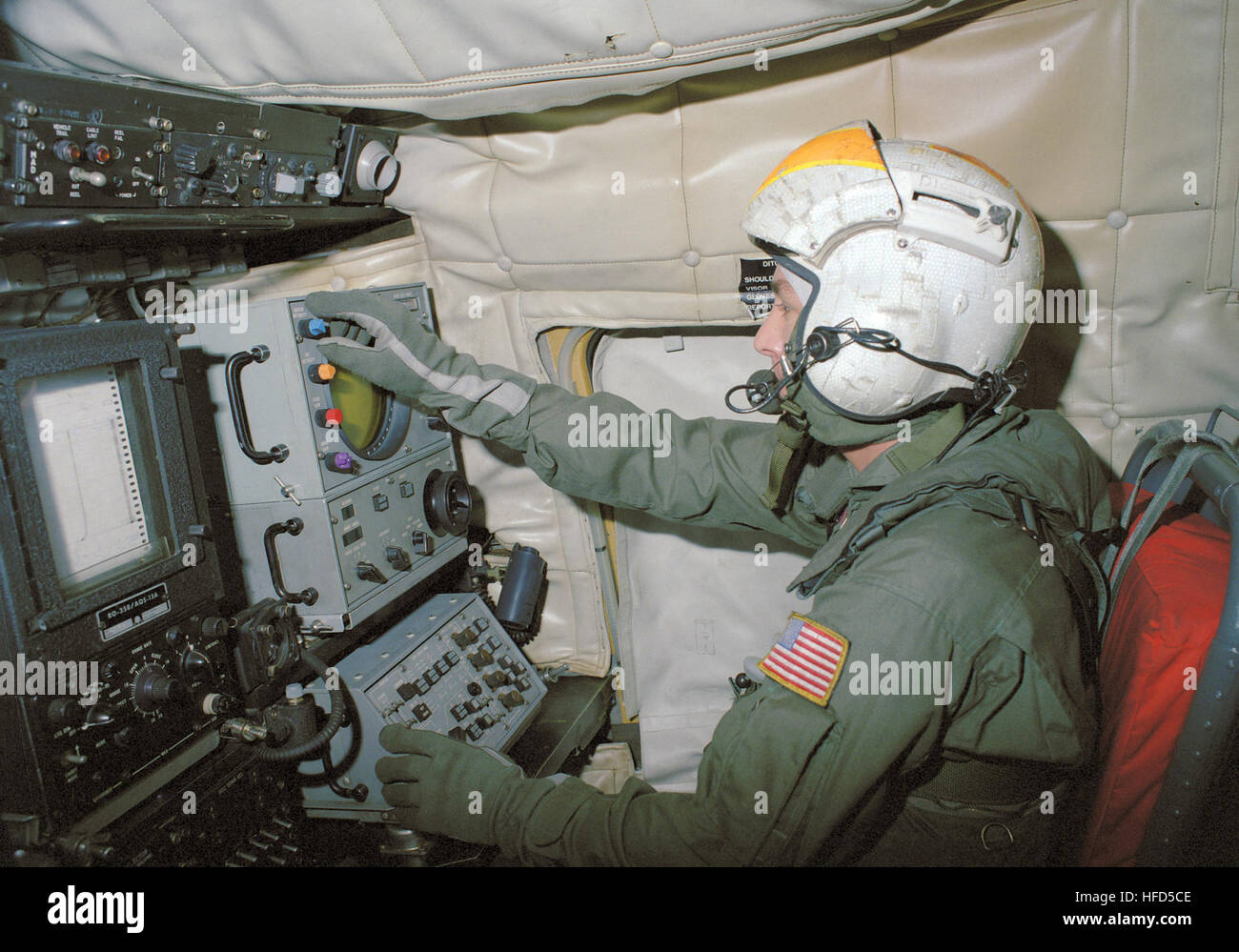 Un aviation anti-guerra sottomarina operatore controlla un/AQS-13 dipping sonar del pannello di controllo all'interno di una SH-3 Sea King elicottero. Operatore sonar in SH-3H Mare Re 1987 Foto Stock