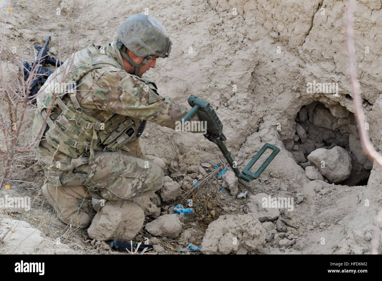 Un membro della coalizione di forze per le operazioni speciali utilizza un rivelatore di metalli per la ricerca di un sospetto di armi cache durante una pattuglia guidata da afghano di Polizia Locale in Walan Rabat village, Provincia di Zabul, Afghanistan, gen. 4. (U.S. Foto di Marina di Massa lo specialista di comunicazione 2a classe Jon Rasmussen / Non rilasciato) afgano Polizia Locale 120104-N-CI175-025 Foto Stock