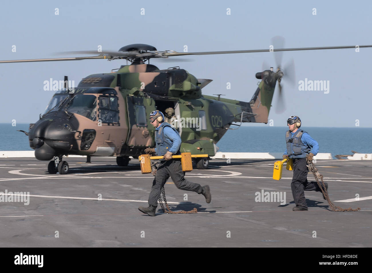 150710-N-TW634-799 OCEANO INDIANO (10 luglio 2015) il cuneo e la catena dei marinai sul ponte di volo del trasporto anfibio dock nave USS Green Bay (LPD 20) eseguito come un esercito australiano MRH-90 elicottero si prepara a decollare. Green Bay è nell'Oceano Indiano che partecipano a Talisman Sabre 2015. Talisman Sabre è un esercizio di bilaterali destinati al treno australiano e le forze USA nella pianificazione e conduzione delle attività combinate operazioni vigore. (U.S. Foto di Marina di Massa lo specialista di comunicazione di terza classe Derek A. Harkins/RILASCIATO) talismano Sabre 2015 150710-N-TW634-799 Foto Stock