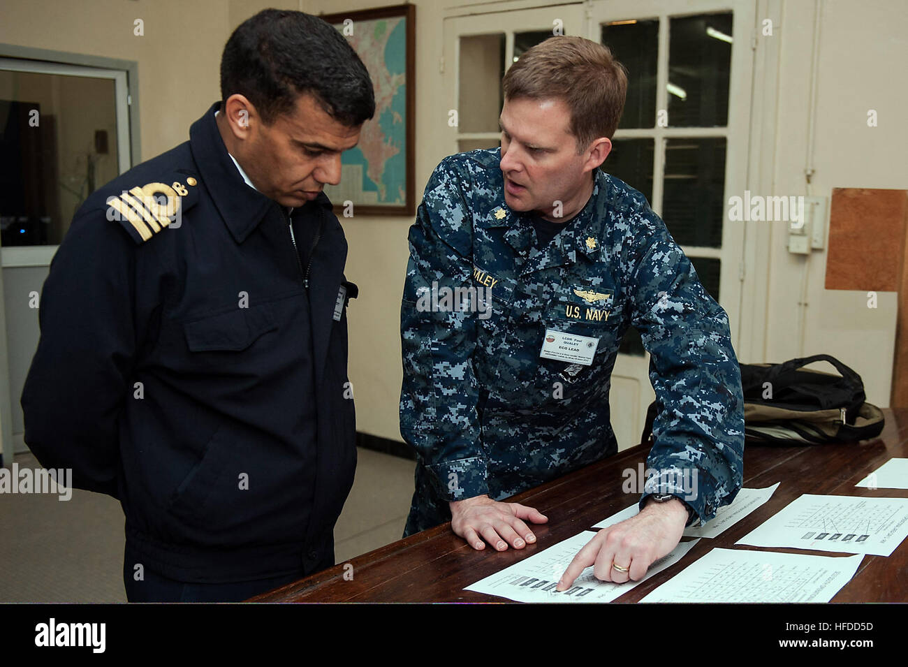 Lt. La Cmdr. Paolo Qualey, destra, Stati Uniti esercitano il controllo gruppo piombo, le vie di navi con la Royal Navy marocchino Lt. La Cmdr. Mohamed Ezzoubairi nelle operazioni marittime center all'Admiral Faye Gassama Base Navale durante la fase di esercizio del Sahara Express 2013. Saharan Express è un marittimo internazionale di cooperazione per la sicurezza esercizio inteso a migliorare la sicurezza marittima e la sicurezza in Africa occidentale. (U.S. Foto di Marina di Massa lo specialista di comunicazione di terza classe Brian T. Glunt/RILASCIATO) U.S. Navy Lt. La Cmdr. Paolo Qualey, destra, gli Stati Uniti esercitano il controllo gruppo piombo, le vie di navi con la marina militare marocchina Lt. La Cmdr. Mohamed Ezzou Foto Stock