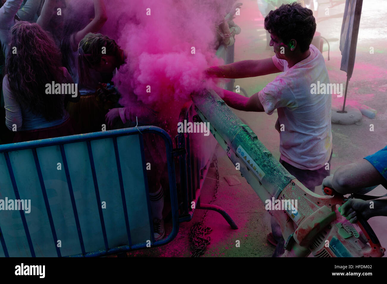 Di colore verde e rosa polvere spruzzata su un giovane ben educato rave party folla a Milano Foto Stock