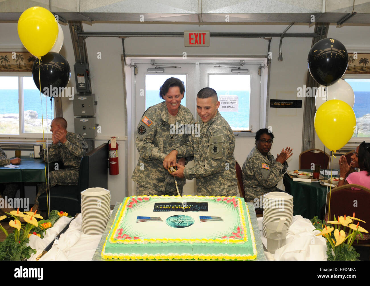 GUANTANAMO Bay a Cuba - Esercito Col. Linda Ross e esercito Pvt. Justin Champion, attaccato alla Joint Task Force Guantanamo, tagliare una torta di compleanno in onore dell'esercito la 235th compleanno, 14 giugno 2010. JTF Guantanamo conduce al sicuro, umano, legale e trasparente di cura e custodia dei detenuti, compresi quelli condannati dalla commissione militare e quelli ordinati rilasciato da un tribunale. La JTF conduce la raccolta di intelligence, analisi e diffusione per la tutela dei detenuti e il personale che lavora in JTF Guantanamo strutture e a sostegno della guerra al terrore. JTF Guantanamo fornisce il supporto al di Foto Stock