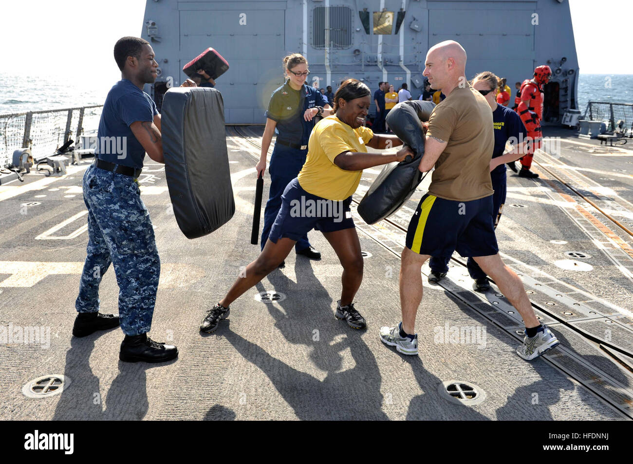 Stati Uniti 5TH FLOTTA AREA DI RESPONSABILITÀ (GEN. 23, 2013) Yeoman 1a classe Charma laghetti, centro pratiche tattiche non letali su Gunner compagno del 3° classe Mandley Dinobadele, sinistra e Chief Fire Controlman James Daniels dopo che viene spruzzato con Oleoresin Capsicum durante la sicurezza della forza di reazione della formazione a bordo guidato-missile destroyer USS Jason Dunham (DDG 109). Jason Dunham è distribuito con il John C. Stennis Strike gruppo per gli Stati Uniti Quinta Flotta area di responsabilità condurre le operazioni di sicurezza marittima, teatro la cooperazione in materia di sicurezza gli sforzi e le missioni di sostegno per l'Operazione Enduring Freedom Foto Stock