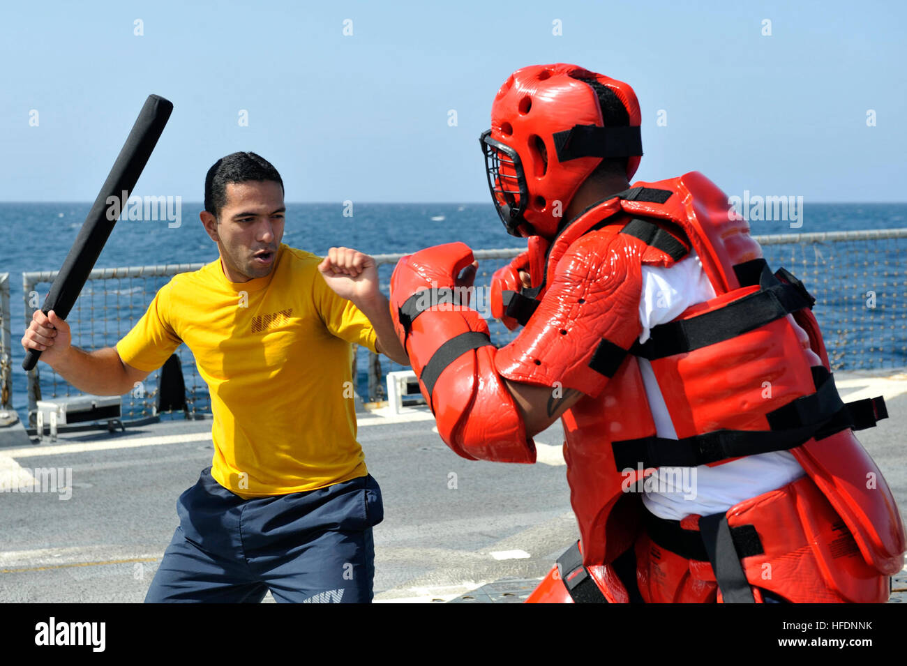 Stati Uniti 5TH FLOTTA AREA DI RESPONSABILITÀ (GEN. 23, 2013) Quartermaster 2a classe Johnathan Restrepo, sinistra, pratiche tattiche non letali sui sistemi di informazione tecnico di terza classe Jasmaine Brooks dopo che viene spruzzato con Oleoresin Capsicum durante la sicurezza della forza di reazione della formazione a bordo guidato-missile destroyer USS Jason Dunham (DDG 109). Jason Dunham è distribuito con il John C. Stennis Strike gruppo per gli Stati Uniti Quinta Flotta area di responsabilità condurre le operazioni di sicurezza marittima, teatro la cooperazione in materia di sicurezza gli sforzi e le missioni di sostegno per l'Operazione Enduring Freedom. (U.S. Navy foto di M Foto Stock