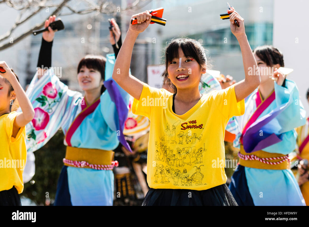 Yosakoi Hinokuni Festival. Bambino ballerino, ragazza in Simpsons t-shirt, Ballare come parte del team, mani sollevate sopra la testa tenendo naruko, battagli di legno. Foto Stock