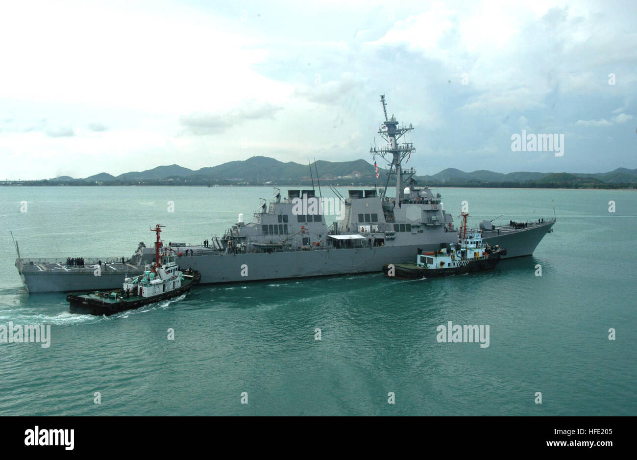 040708-N-4104L-031 Sattahip, Thailandia (8 luglio 2004) Ð il missile destroyer USS Russell (DDG 59), è assistita da due rimorchiatori come esso ritorna al porto a seguito della Thailandia fase di esercizio la cooperazione a galla la prontezza e la formazione (Carati). Russell e le altre navi della CARAT Task Group ha preso parte a una varietà di eventi operativi con le navi della Marina Militare tailandese durante la fase in corso di esercizio. Carato è un pianificate regolarmente serie di accordi bilaterali di esercizi con diversi Southeast Asia nazioni progettate per migliorare l'interoperabilità dei rispettivi servizi marittimi. Foto Stock