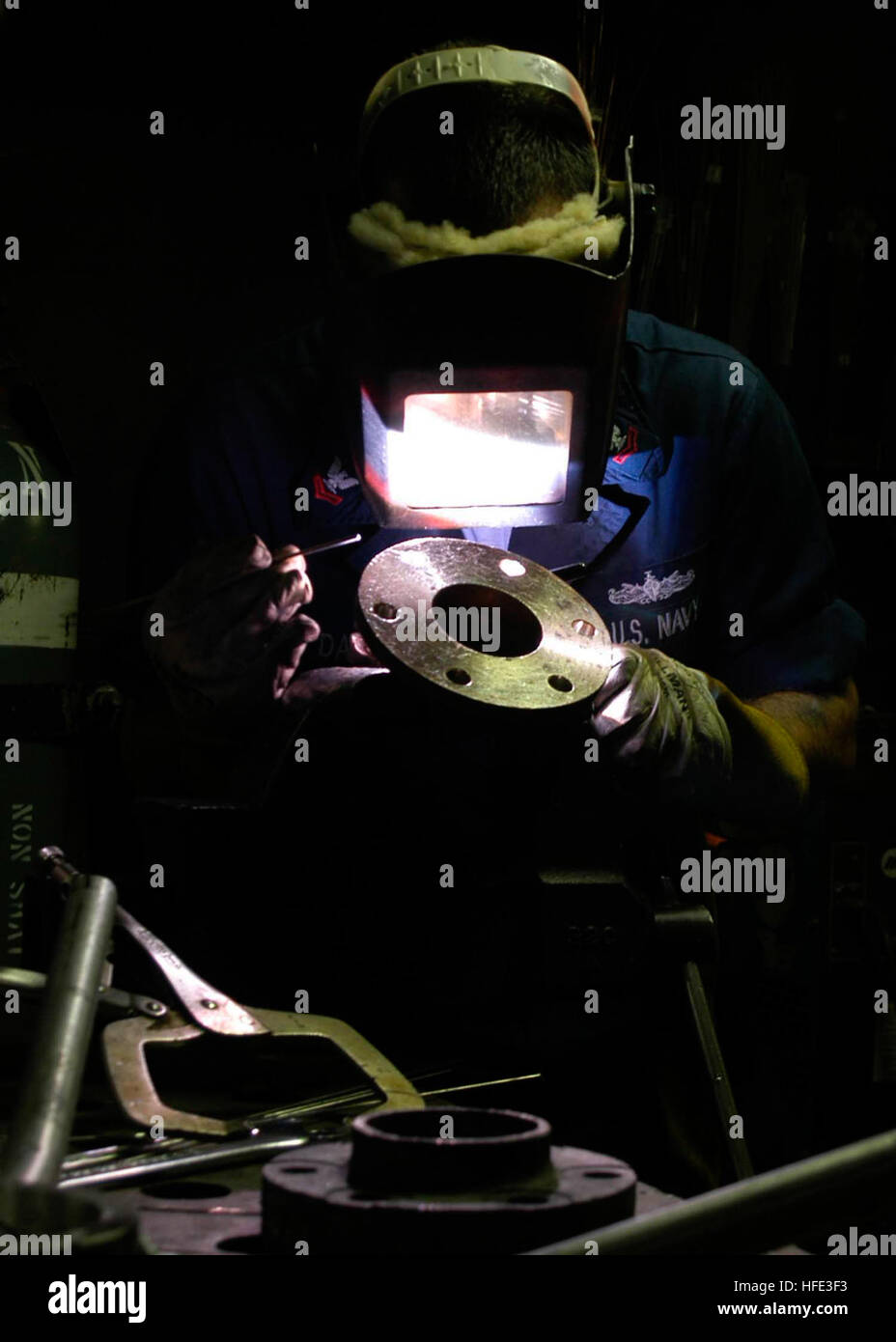 Hull Technician 2nd Class salda un gomito a bordo della USS Abraham Lincoln (CVN 72) come parte della manutenzione della nave e della preparazione per lo spiegamento. Il lavoro viene svolto dalla Divisione riparazioni per garantire la prontezza operativa e l'integrità strutturale della portaerei. Foto Stock