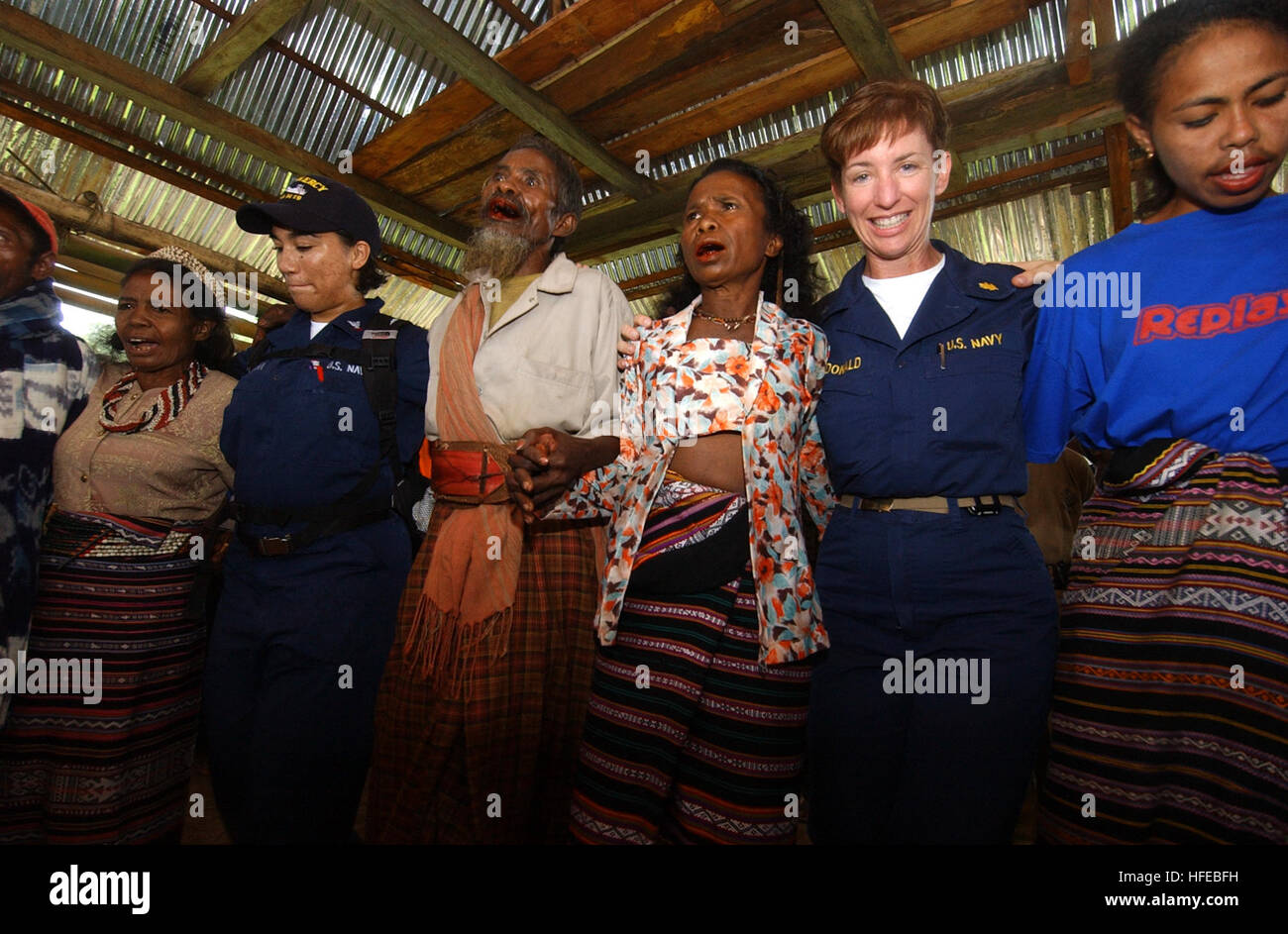 050328-N-6665R-281 Alor, Indonesia (Mar. 28, 2005) Ð Cmdr. Karen McDonald, secondo da destra, e l'Ospedale Corpsman 3rd Class Judith Quintana, la seconda da sinistra, membri delle forze militari di comando Sealift (MSC) nave ospedale USNS misericordia (T-AH 19) Apui team clinico, danza con i membri del villaggio Apui durante una celebrazione per il team medico. Il team fornito tanto necessari medici, dentistici e assistenza civica del villaggio. La misericordia dispiegato nella regione per fornire assistenza umanitaria e la messa a fuoco di cure mediche a migliaia di persone sfollate a causa di un ordine di grandezza 7.3 terremoto che ha colpito il nov. 11, 20 Foto Stock