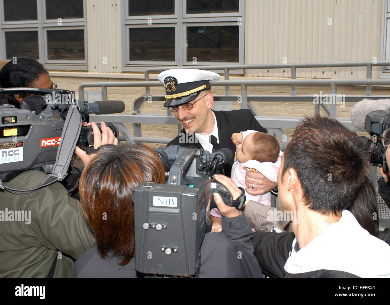 050406-N-2970T-070 Sasebo, Giappone (apr. 6, 2005) Ð Lt.j.g. Andrew Bond è intervistato da supporti in giapponese come egli detiene la figlia per la prima volta durante la celebrazione homecoming per l assalto anfibio nave USS Essex (LHD 2). Essex restituito da otto mesi di distribuzione a sostegno dell'Operazione Iraqi Freedom (OIF), una guerra globale contro il terrorismo e il funzionamento di assistenza unificata, il rilievo di disastro sforzo nel sud-est asiatico dopo il Dic. 26, 2004 tsunami. Stati Uniti Navy foto di PhotographerÕs Mate Airman Marvin E. Thompson Jr. (rilasciato) Navy US 050406-N-2970T-070 Lt.j.g. Andrew Bond è int Foto Stock