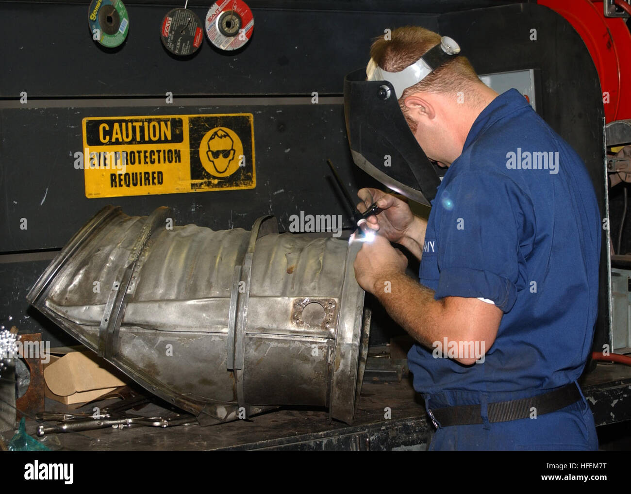 Aviation Structural Mechanic salda una nuova flangia su un collettore di scarico dell'aeromobile presso la Naval Air Station Jacksonville, Florida, il 18 giugno 2003. Foto Stock