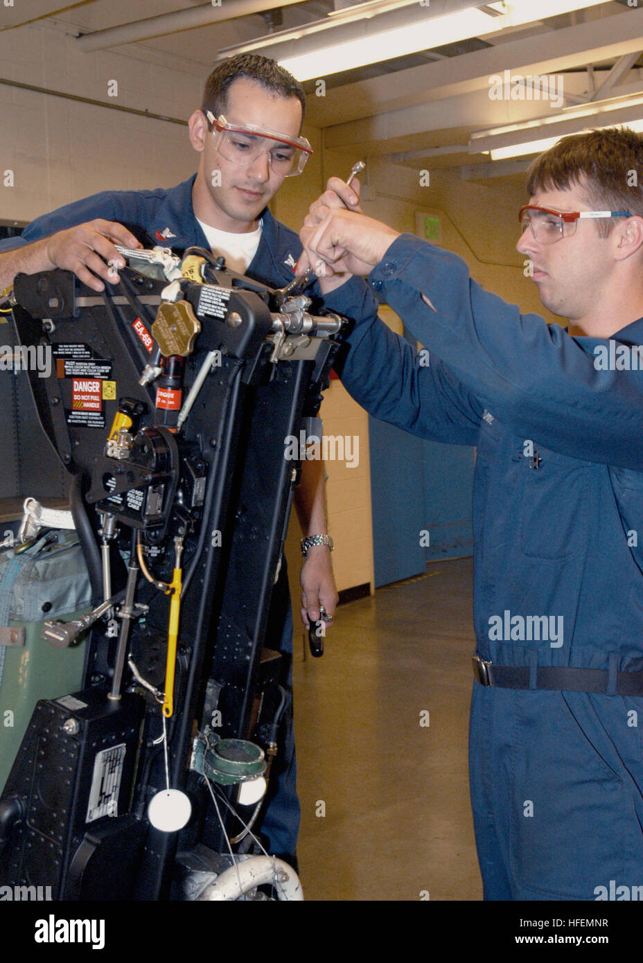 Aviation Structural Mechanics presso la Naval Air Station di Whidbey Island stringe un arco a forbice su un sedile eiettabile EA-6B il 23 luglio 2003. Il lavoro è condotto da personale del reparto Central Egress del reparto di manutenzione intermedia degli aeromobili (AIMD). Foto Stock