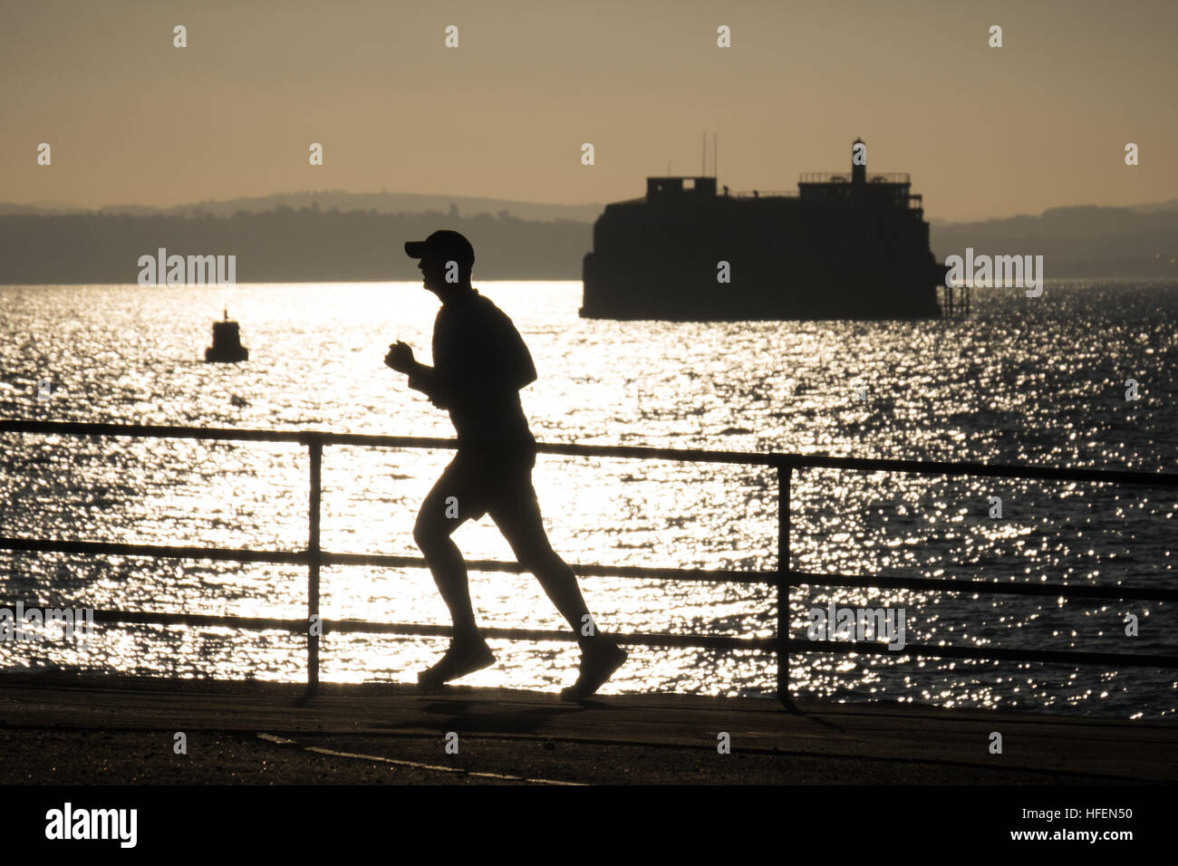 Un runner godendo il sole tra Natale e il nuovo anno il Southsea Promenade Foto Stock