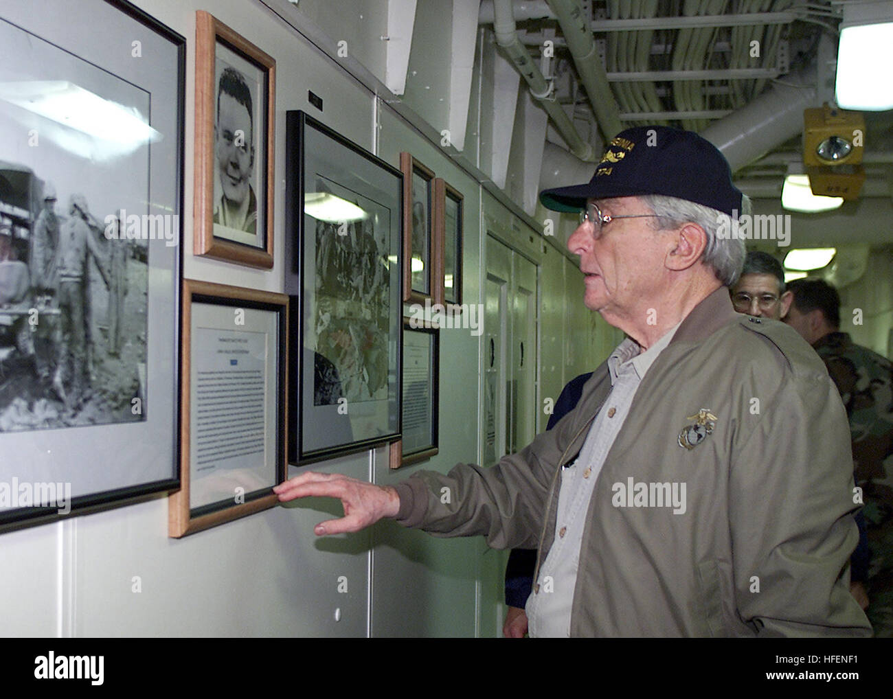 030828-N-2954M-008 Oceano atlantico (Agosto 28, 2003) -- STATI UNITI Il senatore John Warner (R-Va.), Presidente del Senato, Comitato delle Forze Armate, si ferma a guardare le foto scattate durante la Battaglia di Iwo Jima nel 1945 come parte di un tour di USS Iwo Jima (LHD 7). La Warner ha visitato Iwo Jima a osservare le operazioni del multi-purpose Amphibious Assault ship. Più successivamente ha affrontato l'equipaggio della nave e ha elogiato il loro supporto di mantenimento della pace e le missioni umanitarie in Liberia. La Warner ha commentato ÒMy prime parole per voi più importanti sono le parole che conosco in lingua inglese e che è ÔThank si.ÕÓ Iwo Jima è su Foto Stock