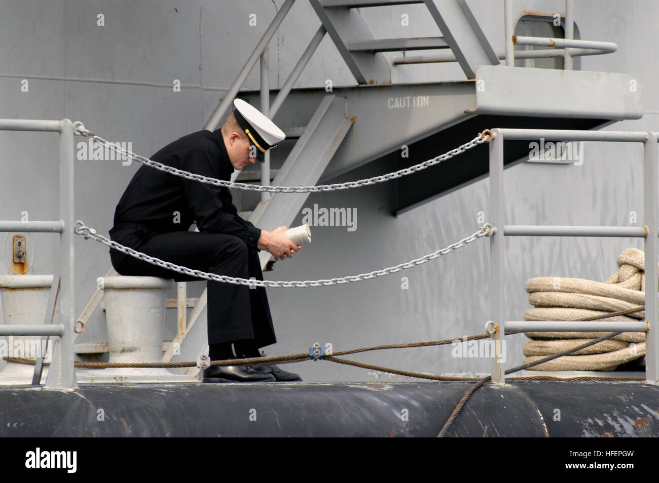 031017-N-0399H-009 US Naval Academy, Annapolis, Md. (ott. 17, 2003) -- il guardiamarina quarta classe Everett catture fino al suo assegnazioni di lettura tra le classi ad essere detenute a bordo U.S. Navy caserma artigianato personale ausiliario accendino Sixty One (APL-61), ormeggiata lungo la U.S. Accademia navale di Dewey Seawall. La chiatta è 90 piedi largo, 360 piedi lungo ed è a cinque piani di altezza. Essa serve come aule temporaneo per aspiranti guardiamarina spostato dall uragano Isabel e dovrebbe essere utilizzata per il resto del semestre. La chiatta è stato utilizzato in passato per gli equipaggi delle navi durante i periodi di cantiere e i Foto Stock