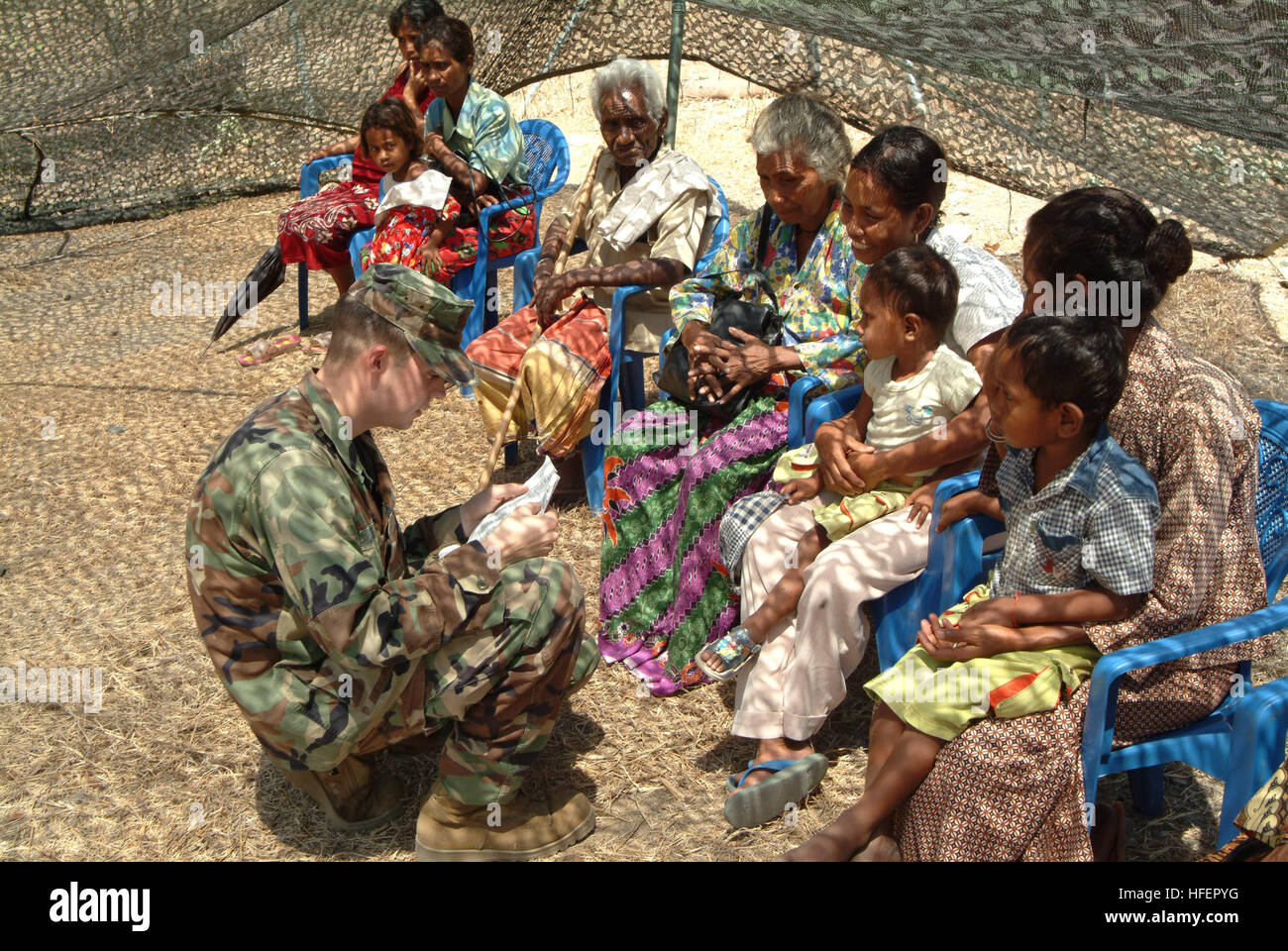 031031-N-9222M-009 Dili, Timor Est (ott. 31, 2003) -- Hospital Corpsman 3rd Class Joshua Stone utilizza pre-tradurre frasi per accertare le esigenze di numerosi abitanti di Timor Est i pazienti in attesa di essere visto da un medico. Un gran numero di Timor Est è apparso in cerca di trattamento a una vista eretta da USS Essex (LHD 2) Il personale medico. L'Essex anfibio gruppo pronto, consistente di Essex, USS Fort McHenry (LSD) 43 e 31 Marine Expeditionary Unit, visitato Timor orientale per fornire assistenza umanitaria. Stati Uniti Navy foto di PhotographerÕs Mate Airman Nicholas C. Messina. (Rilasciato) Navy US 031031 Foto Stock