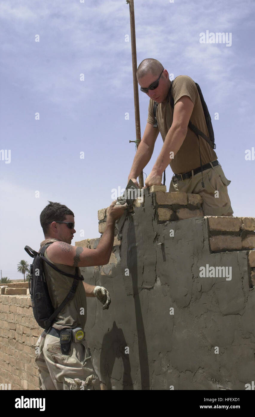 030509-2517J-001 Jassan, Iraq (9 maggio 2003) -- Builder 2a classe Dayman Sommers e ingegneria Constructionman Aiuto Greg Morris stucco il al di fuori di una scuola in Jassan, Iraq. Naval Mobile Battaglione di costruzione una trentina di tre (NMCB-133) è riabilitare la scuola che è stata chiusa per quasi undici anni poiché Saddam HusseinÕs soldati uccisi il principalmente personale sciita. NMCB-133 è in Iraq per fornire il supporto per la costruzione per le forze della coalizione e fornire aiuti umanitari alla popolazione irachena. Stati Uniti Navy foto di PhotographerÕs Mate 2a classe Giacobbe A. Johnson. (Rilasciato) US Navy 03050 Foto Stock
