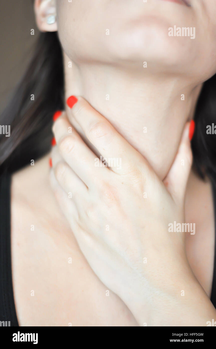 Donna di toccare il suo collo suggerendo il dolore di gola Foto Stock