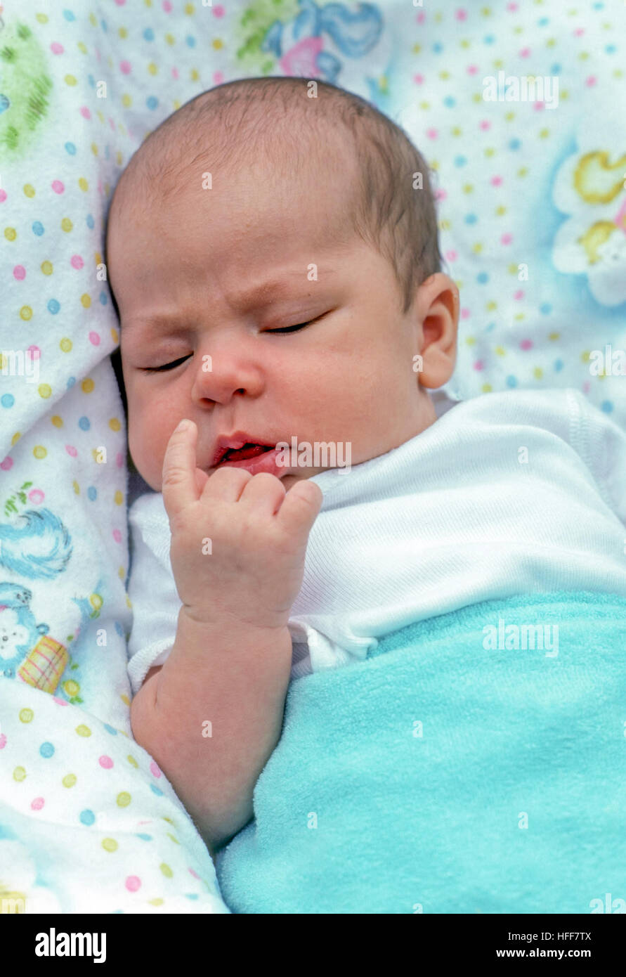 Infant baby boy rendendo volti espressivi e gesti come egli dorme. Foto Stock