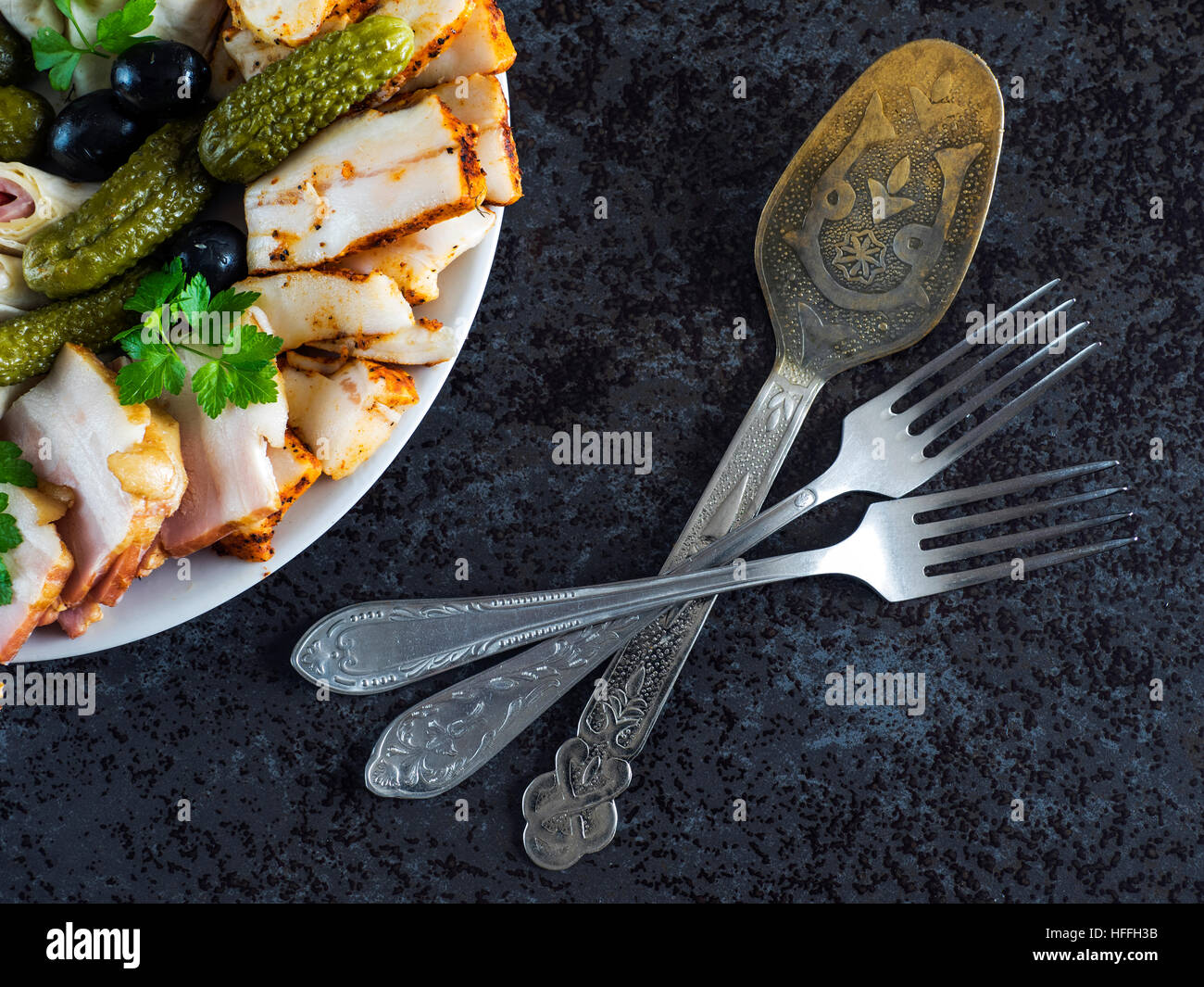 Piatto di Salumi con prosciutto, pancetta, olive e sottaceti Foto Stock