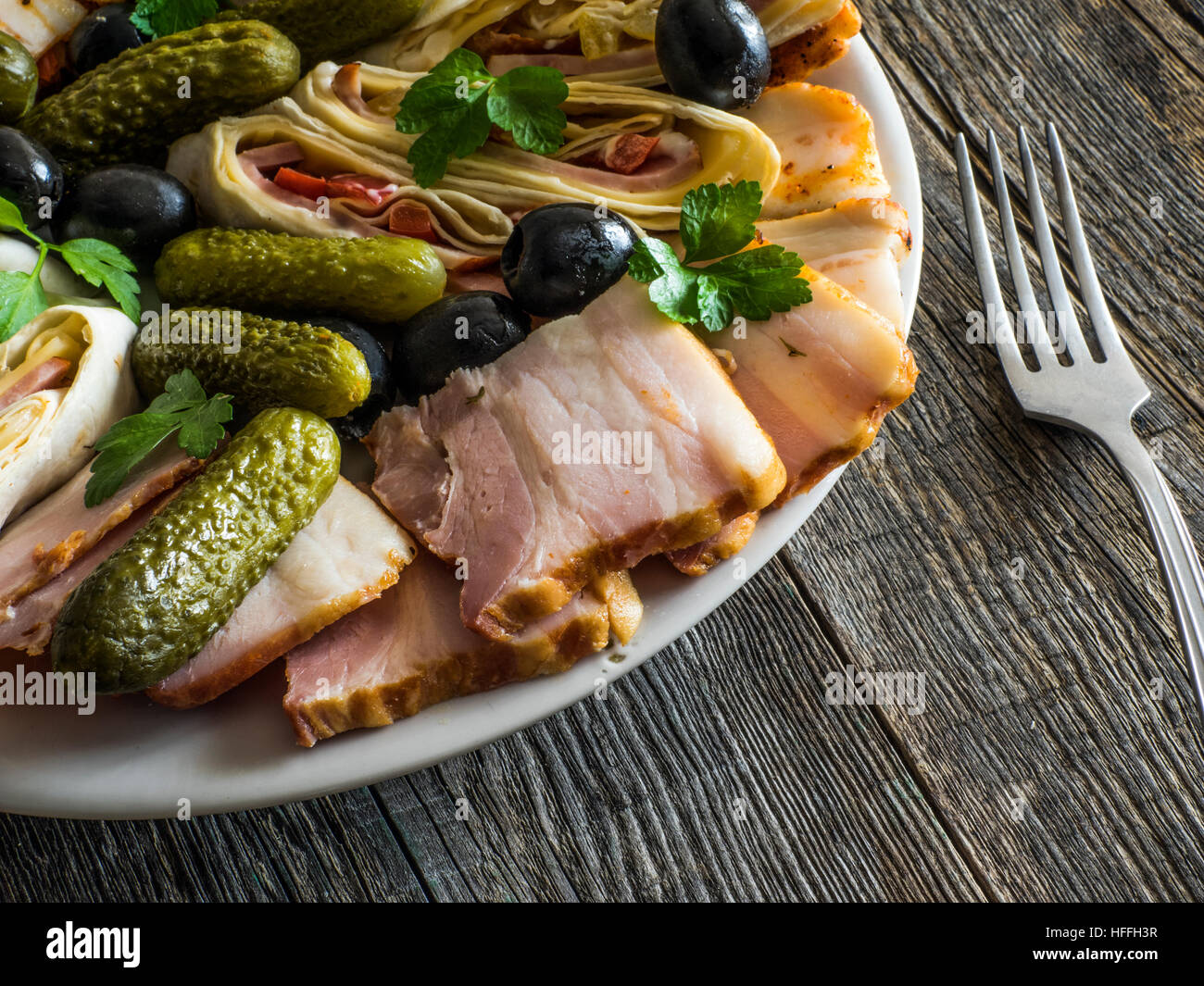 Piatto di Salumi con prosciutto, pancetta, olive e sottaceti Foto Stock
