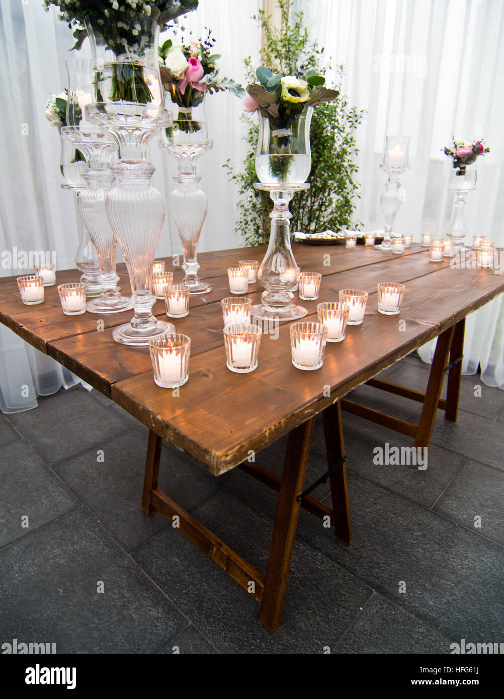 Candele accese su una tavola di legno creano un'atmosfera accogliente, di affetto e di amore Foto Stock