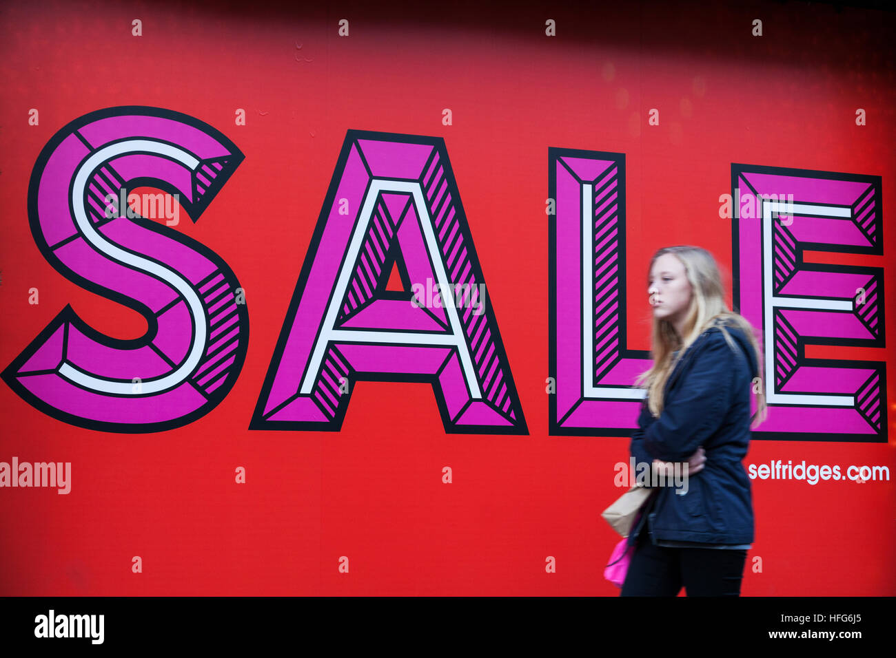 Giovani femmine shopper passeggiate passato vendita segno su Oxford Street, Londra Foto Stock