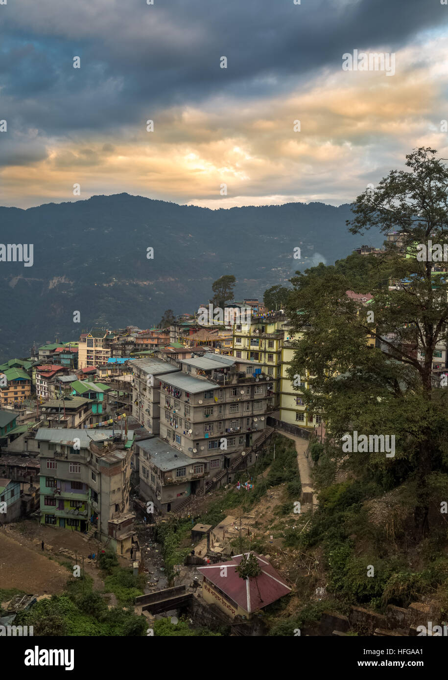 Tramonto sulla città himalayana di Gangtok, con vibranti sky montagne distanti ed edifici. Il Sikkim, India. Foto Stock