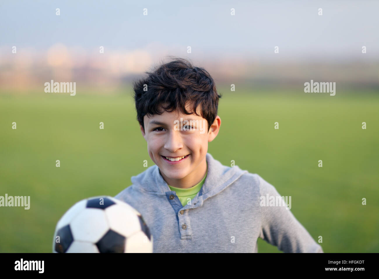 Young Teen boy nel campo di gioco con il calcio durante l ora d'oro - profondità di campo Foto Stock