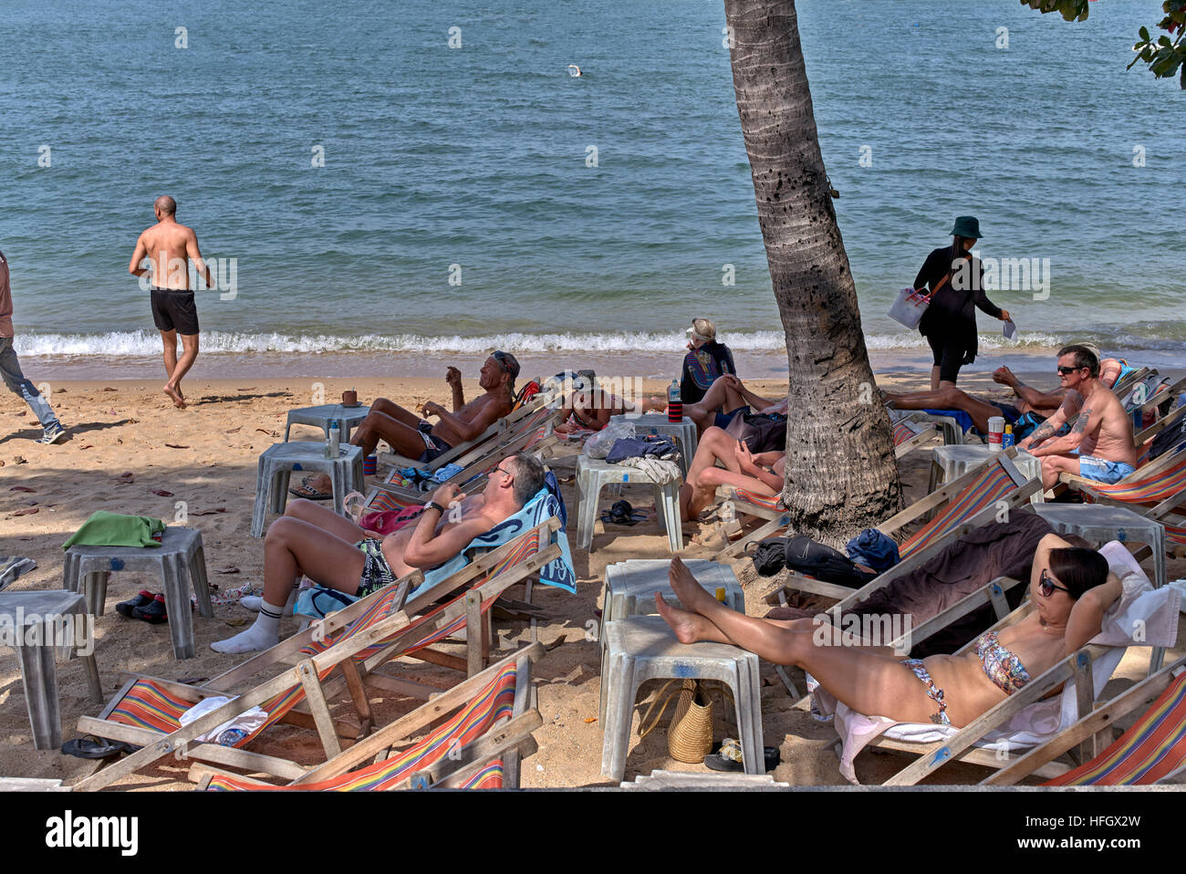 I turisti occidentali a prendere il sole su una spiaggia tropicale. Pattaya Thailandia SUDEST ASIATICO Foto Stock