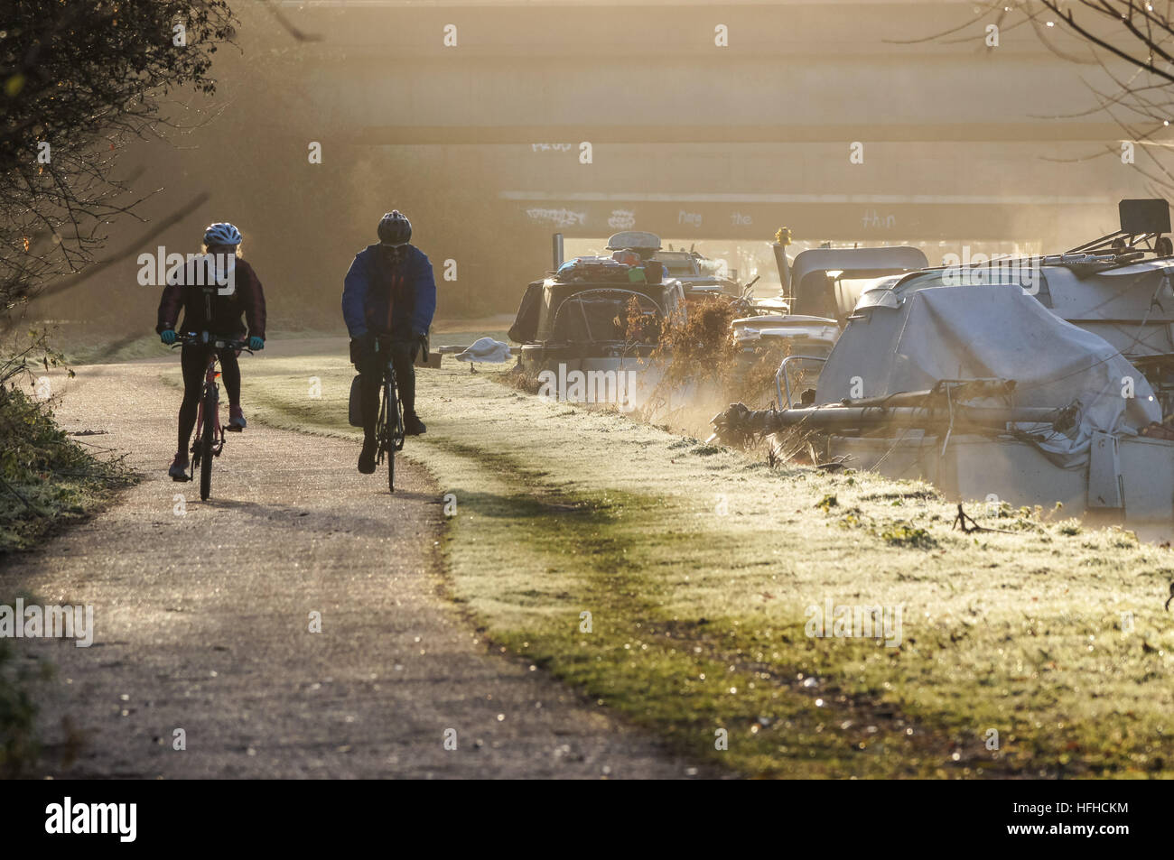 Persone in bicicletta lungo il fiume Lea nella fredda mattina, Londra England Regno Unito Regno Unito Foto Stock Persone in bicicletta lungo il fiume Lea nella fredda mattina, Londra England Regno Unito Regno Unito Foto Stock