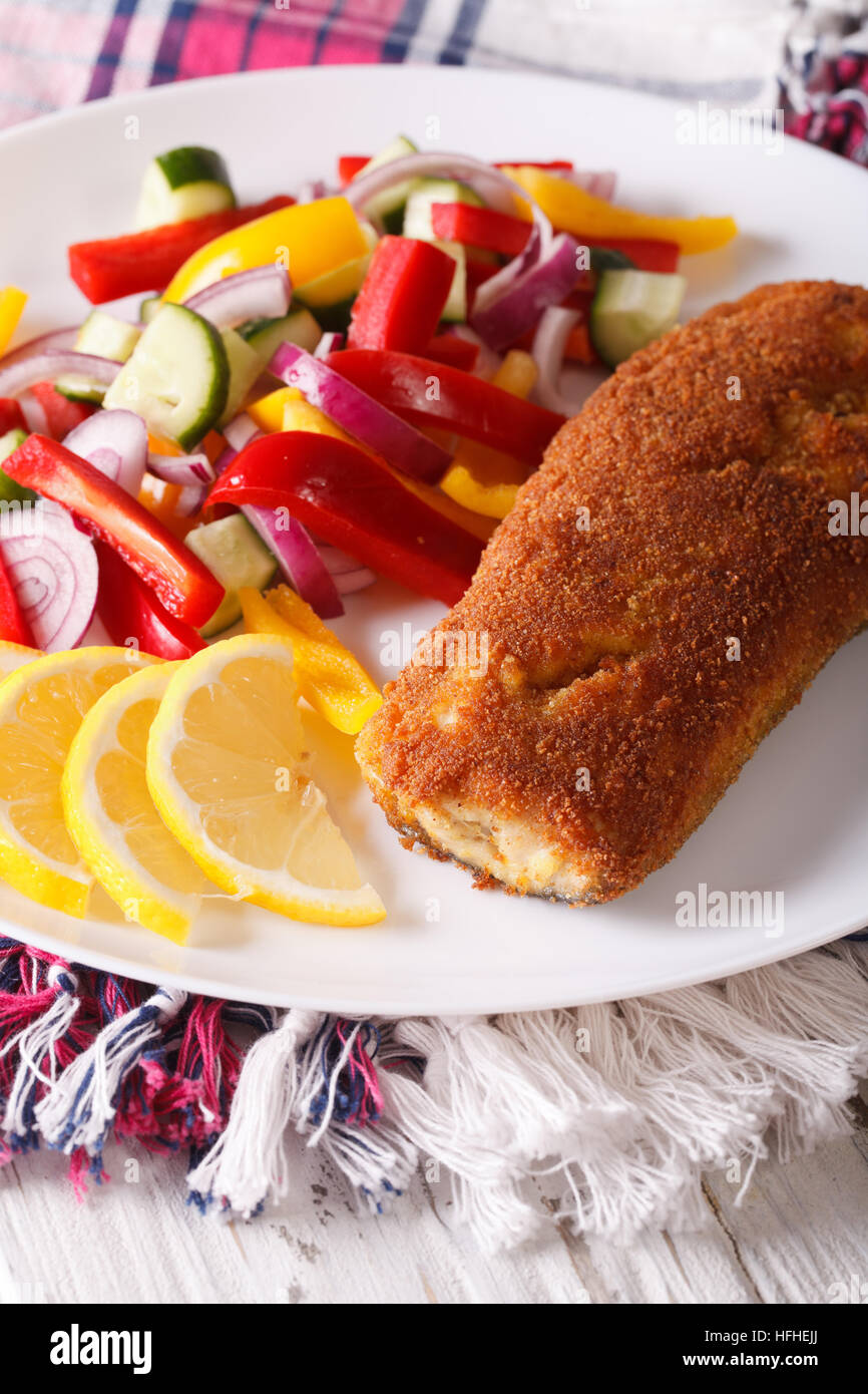 Fritti di filetto di pesce fresco con insalata di verdure sulla piastra closeup. In verticale Foto Stock